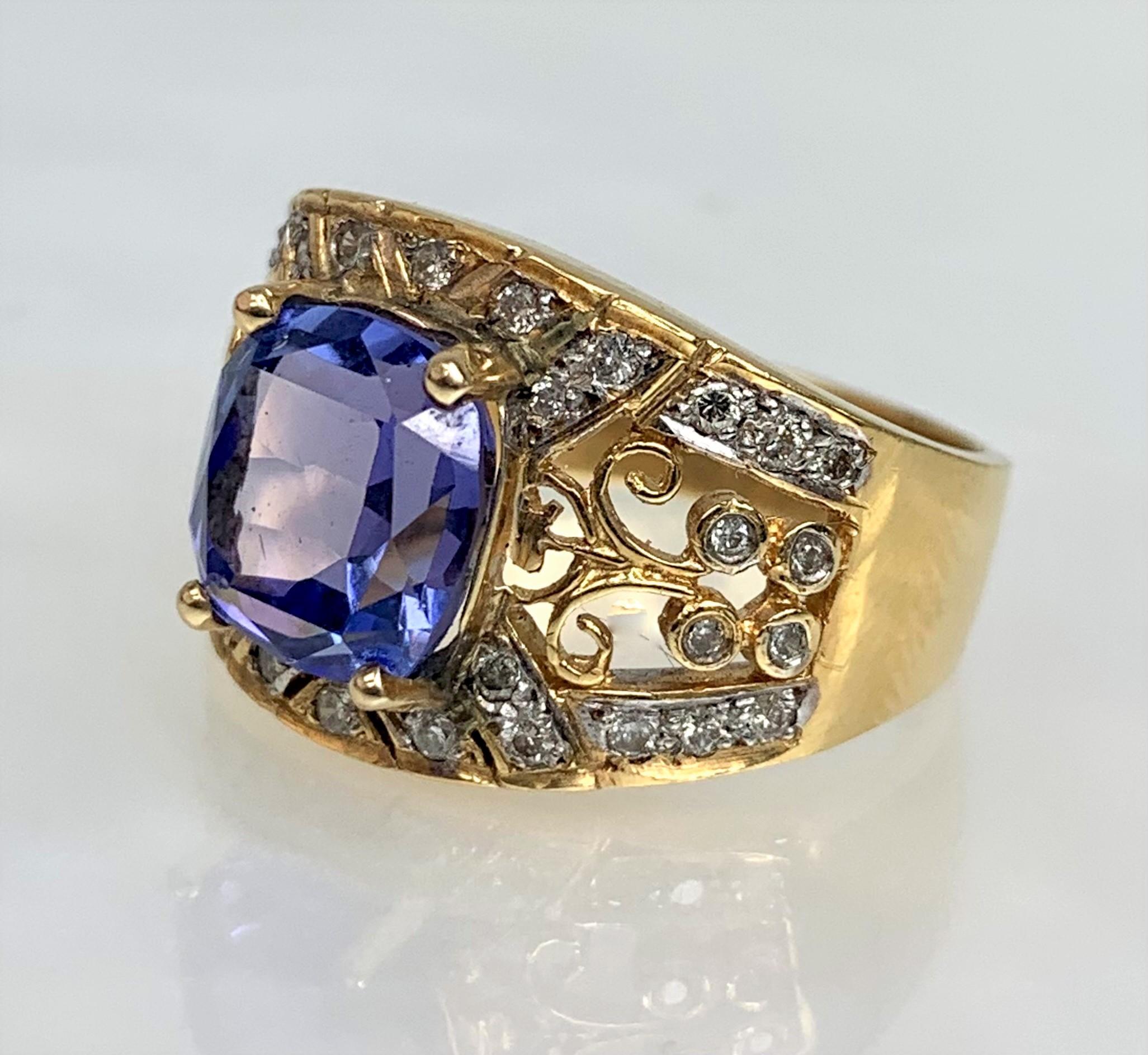 A divine vintage tanzanite ring featuring a 3.90 carat cushion cut center stone surrounded by 0.32 carats of white diamonds set in solid 18k yellow gold with detailed filigree workmanship.

*Approximate stone measurements:
Height: 9mm
Width: