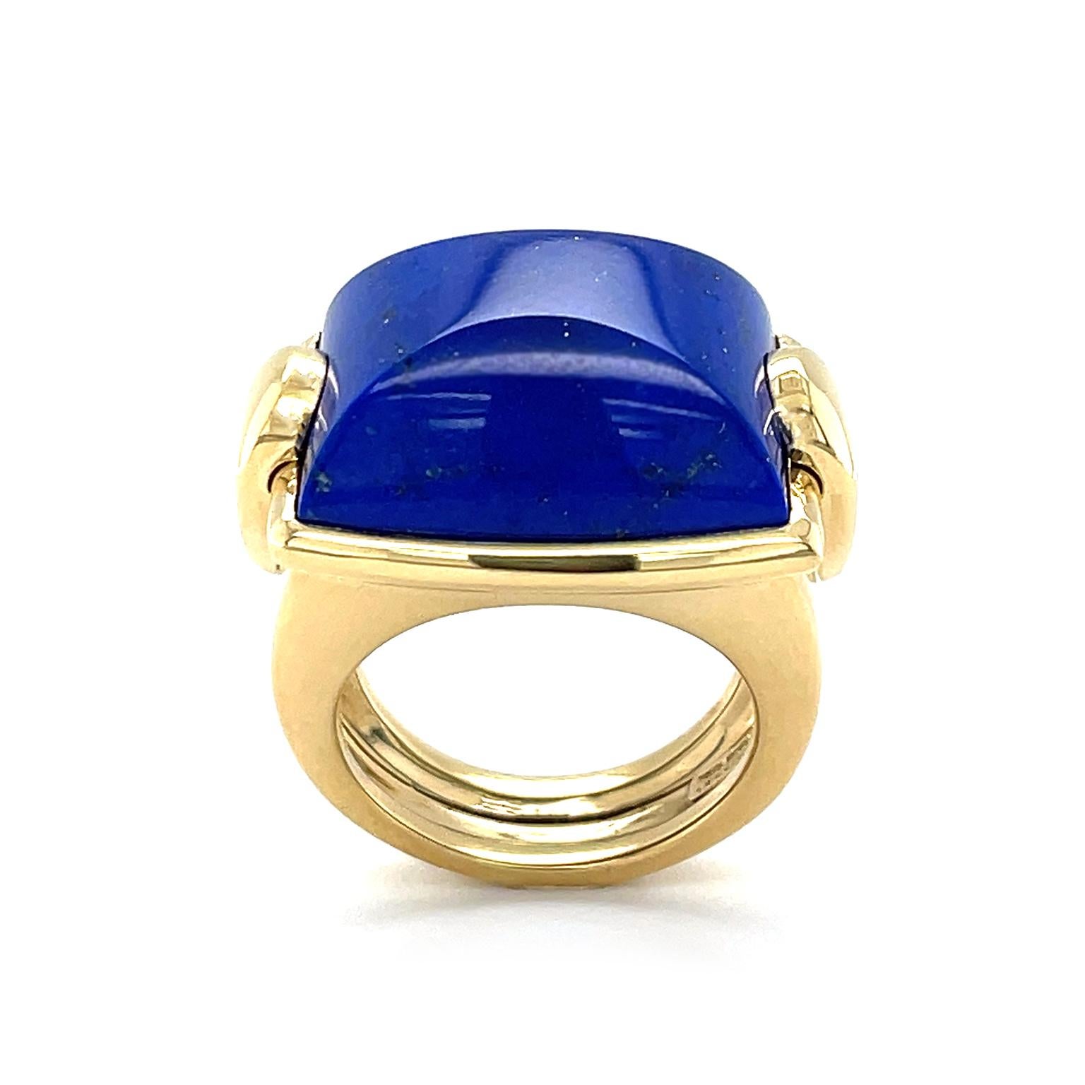 Cobalt-hued lapis lazuli is amplified by the glimmer of 18k yellow gold. A high polish reflects from the cushion shape of the gem. Upturned teardrops of 18k yellow gold are on each side, highlighting the scatter of gold across the lapis lazuli. The