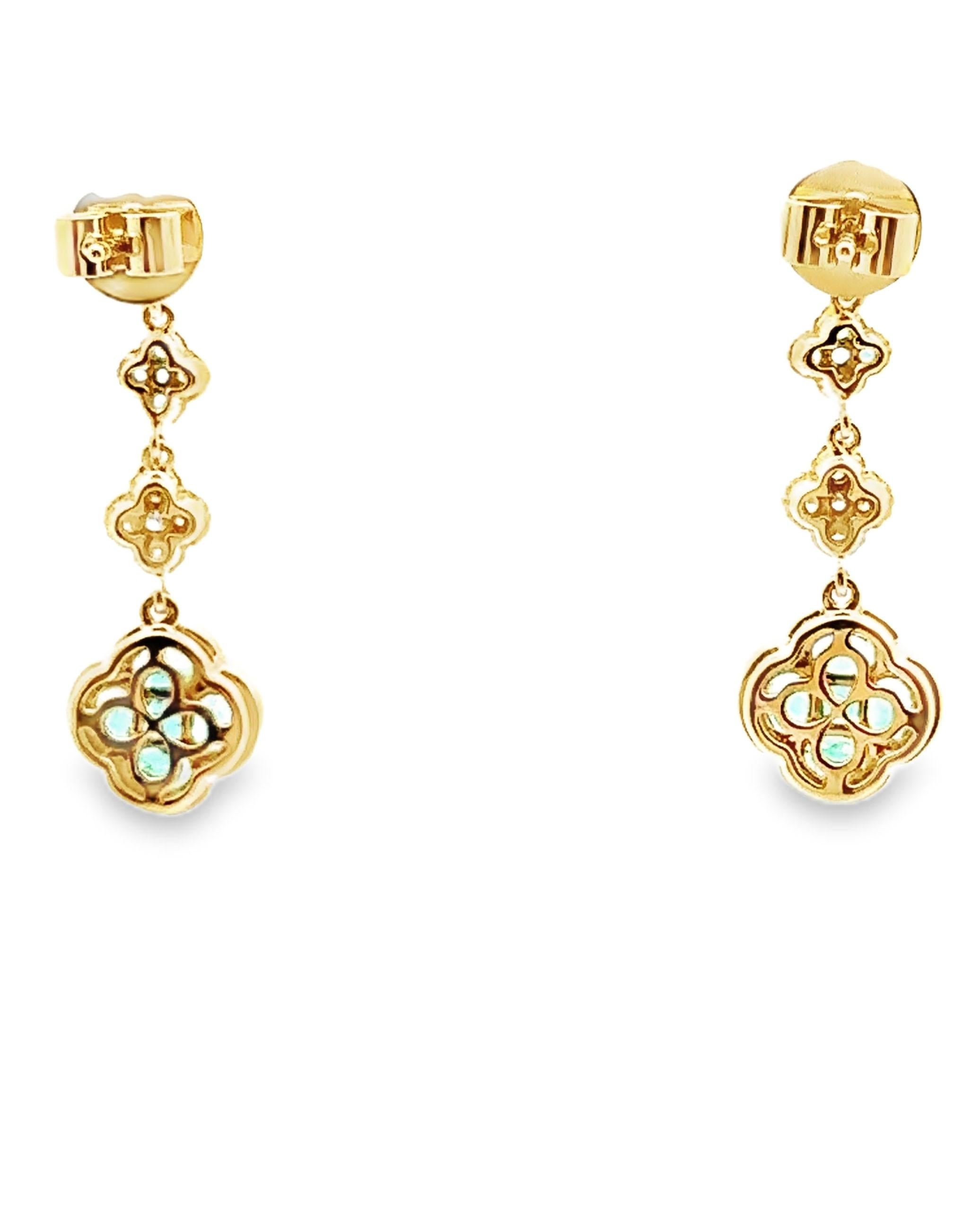 18K yellow gold dangling quatrefoil earrings furnished with round faceted diamonds weighing 0.67 carats total and emeralds weighing 1.31 carats total. 