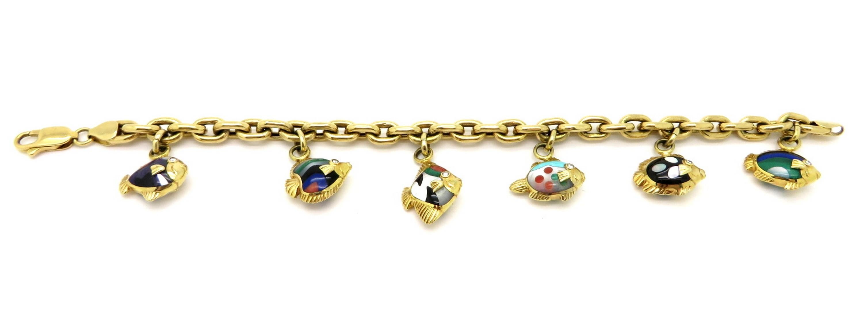 Estate 18K yellow gold designer Asch Grossbardt multi-stone and diamond inlaid fish charm bracelet. Displaying 12 gold fish charms with multi gemstone inlays. The bracelet features a rolo link design with a high polish finish. It is secured with a