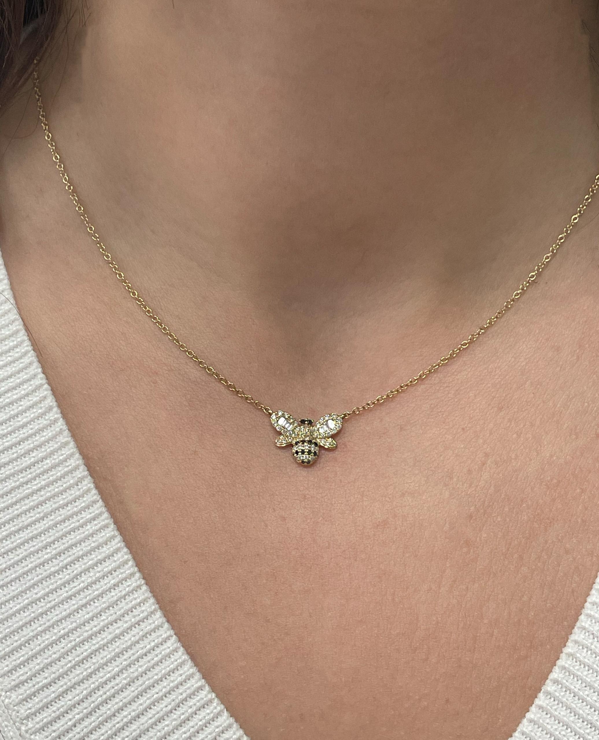 Collana con ciondolo a forma di ape in oro giallo 18 carati con diamanti neri rotondi del peso totale di 0,08 carati, diamanti rotondi del peso totale di 0,21 carati e sei diamanti baguette del peso totale di 0,07 carati.  

- La collana può essere