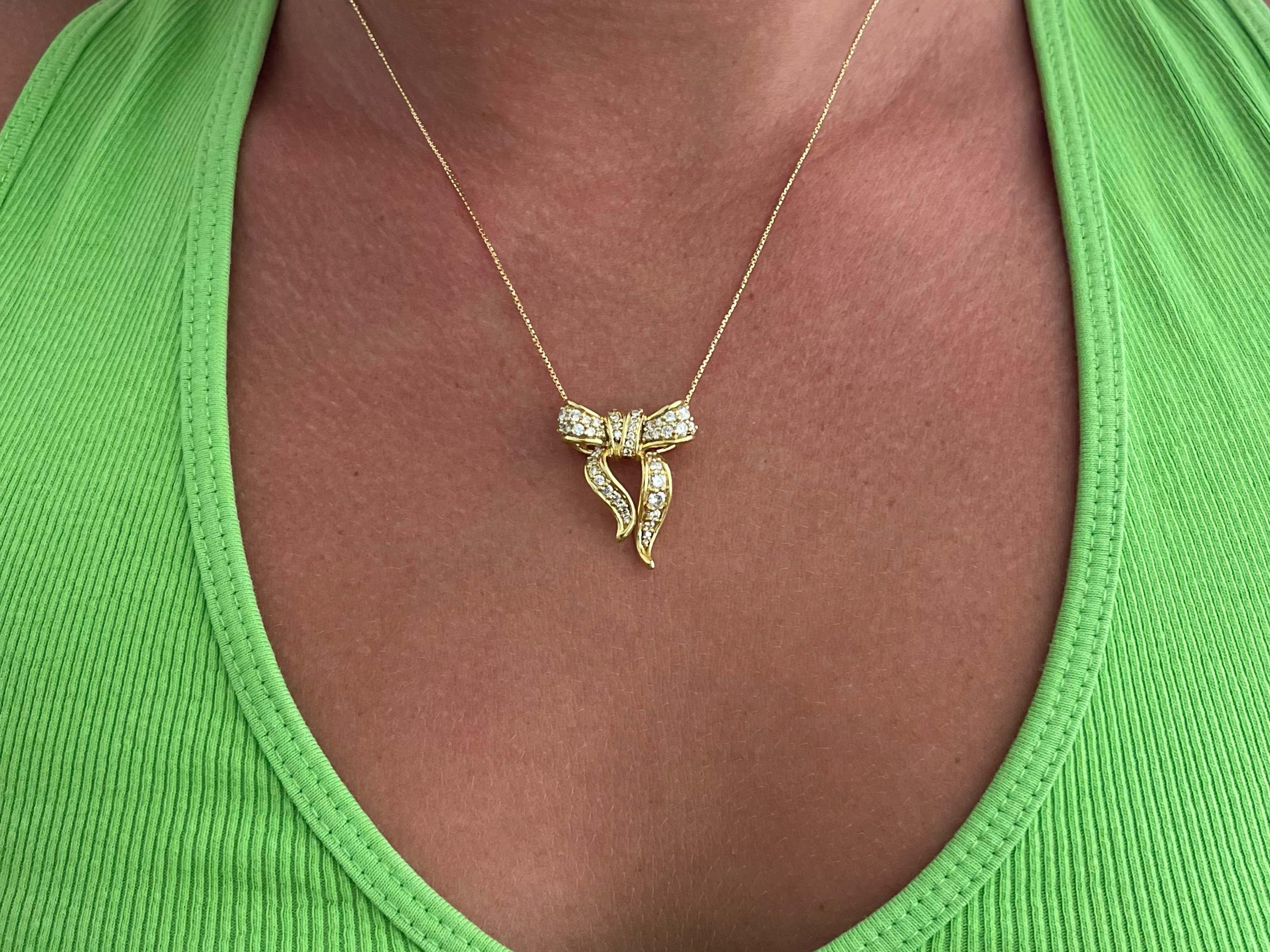 Dieser wunderschöne diamantbesetzte Bogenanhänger besteht aus 46 Diamanten, Farbe G, Reinheit VS1, mit einem Gesamtgewicht von etwa 1,50 Karat. Dieser Anhänger und die Kette sind aus 18 Karat Gelbgold gefertigt. Der Anhänger ist 27 mm hoch und 22,6