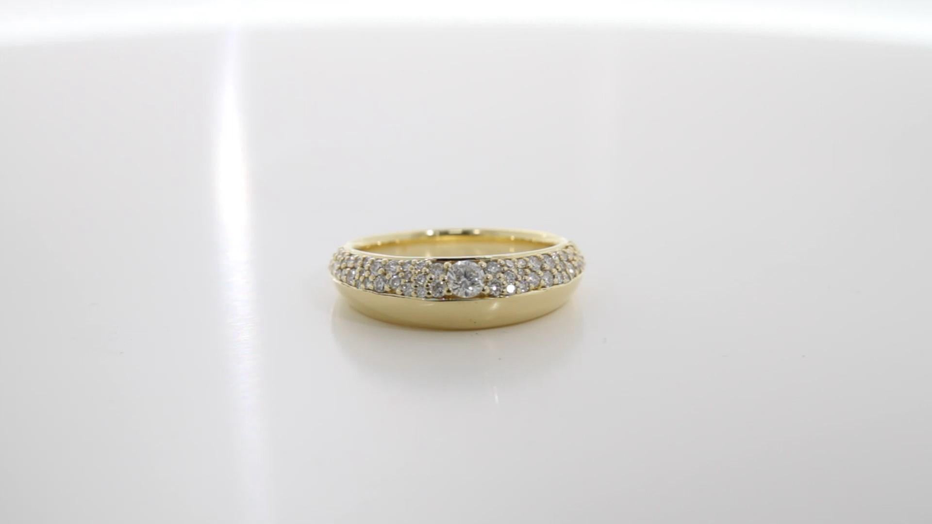 Cette exquise bague habillée en or jaune 18 carats, ornée de diamants, témoigne d'une élégance intemporelle agrémentée d'une touche de modernité. Réalisé en luxueux or jaune 18 carats, ce modèle présente un anneau mi-or rehaussé de diamants