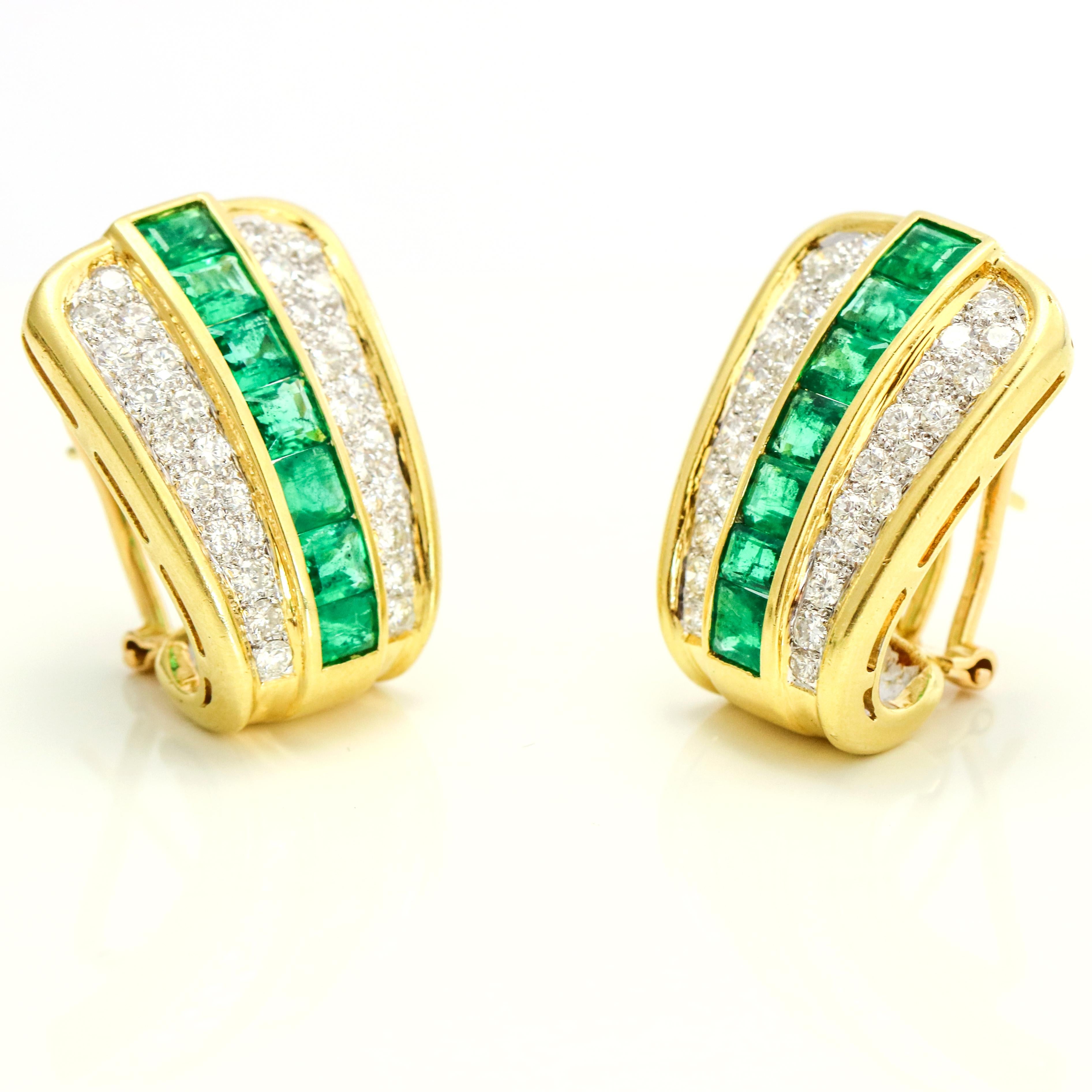 Retro shield earrings in 18-karat yellow gold with natural emeralds and diamonds. The earrings are prong set with 64 round diamonds, and 14 channel-set step cut emeralds. Omega backs.

Diamond Total Carat Weight, 1.50 carats