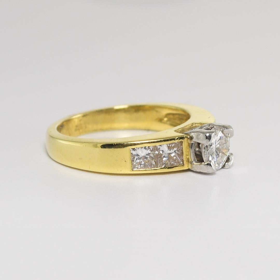 18k yellow gold ring with diamonds.
Not marked 18k, but tests positive for 18k.
The center diamond is a round brilliant cut, .54 carats, G-H-I color, si1-SI2 clarity.
There are four princess cut diamonds on the sides in a channel setting, .76 carats