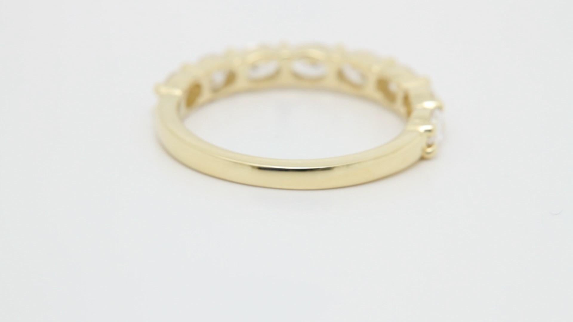 Cette alliance en or jaune 18 carats avec diamants présente une élégance intemporelle avec une touche contemporaine. Présentant des diamants de taille ovale sertis selon une orientation est-ouest, le design met en valeur la forme unique de chaque