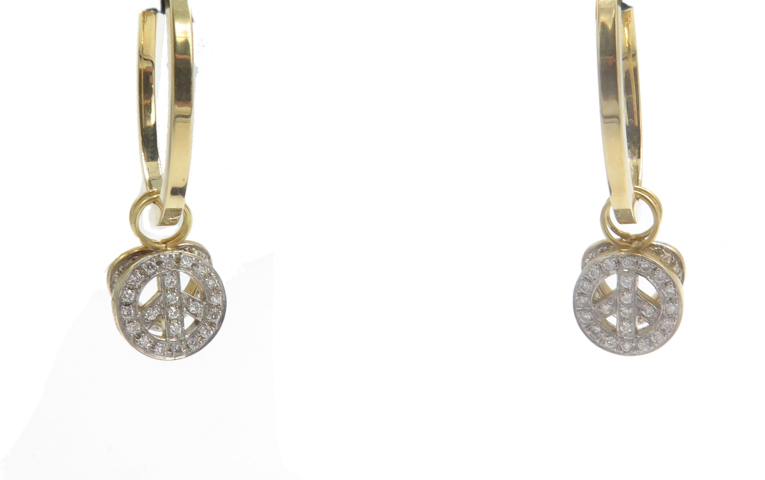 A, lovely pair of 18k yellow gold hoop earrings. These, hoop earrings have two attachments a diamond heart and diamond peace sign  that can be removed and taken off to wear these earrings in various styles or alone with no accessories. The, earring