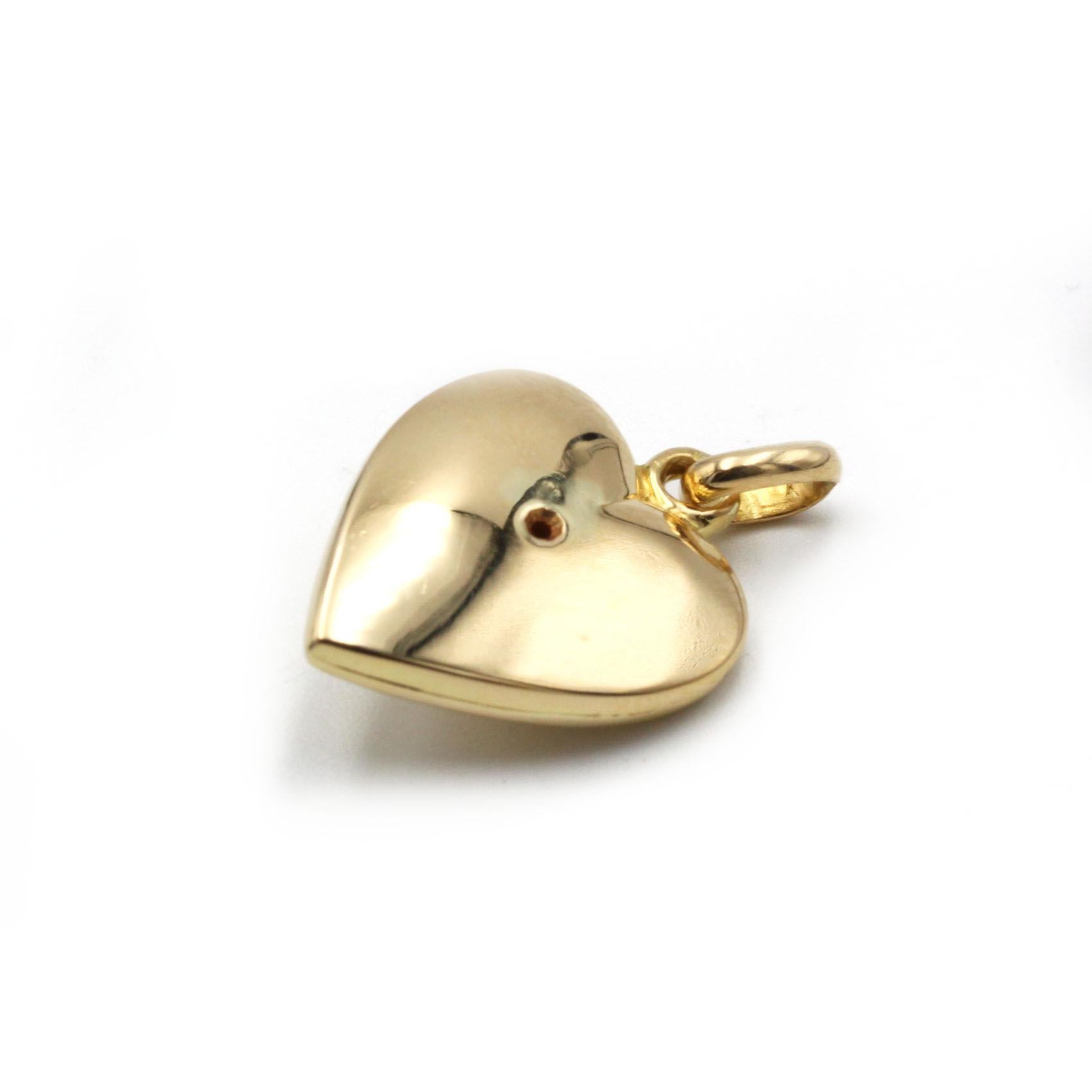 Emblème intemporel de l'amour et de l'élégance, ce pendentif en or jaune 18 carats est magnifiquement sculpté dans une silhouette de cœur classique aux contours délicatement arrondis. En son centre, un diamant rond brillant de 0,15 carat H-VS est