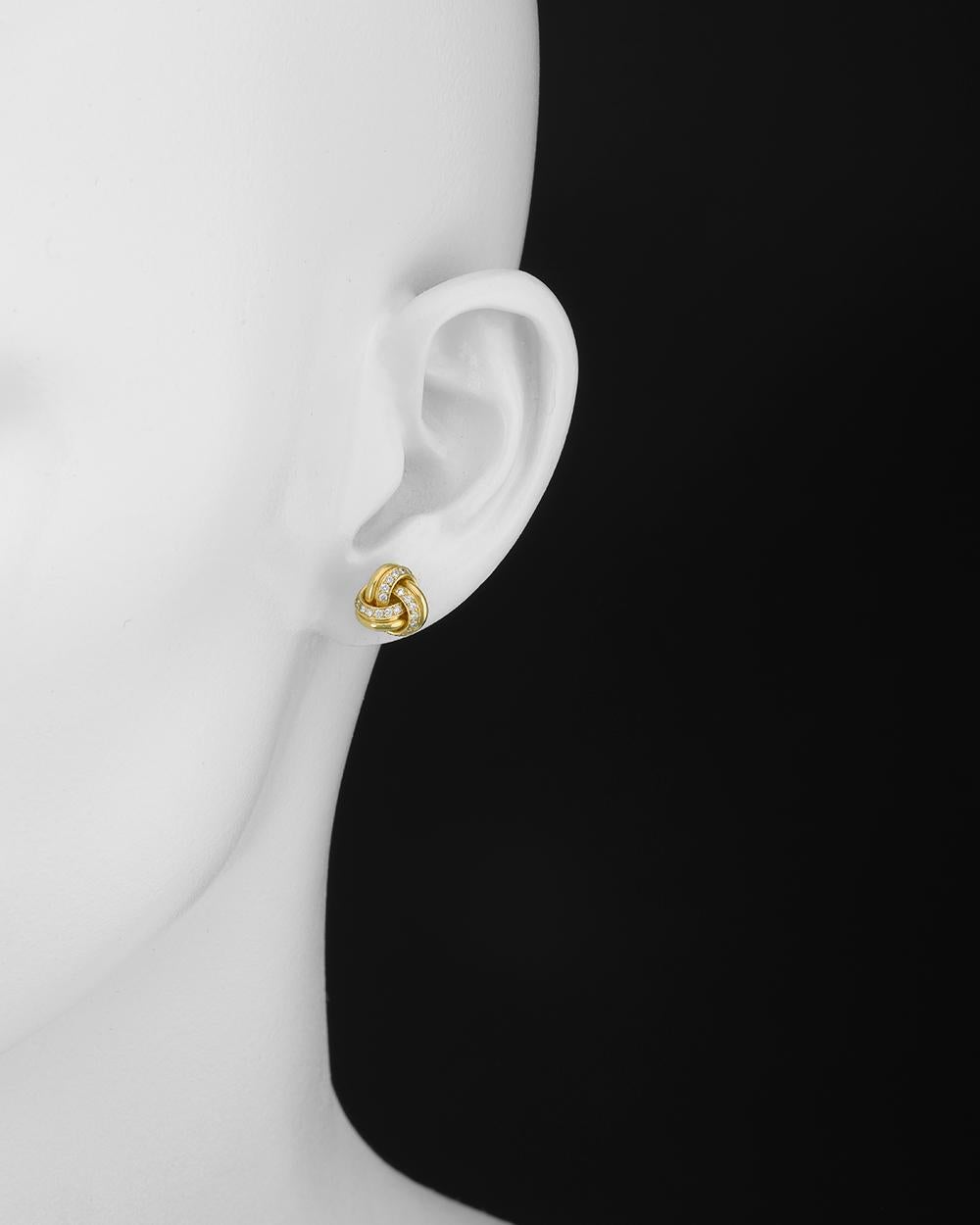 Three-loop knot earstuds in polished 18k yellow gold with pavé diamonds. Round-cut diamonds weighing 0.35 total carats. Posts with friction backs for pierced ears. 0.43