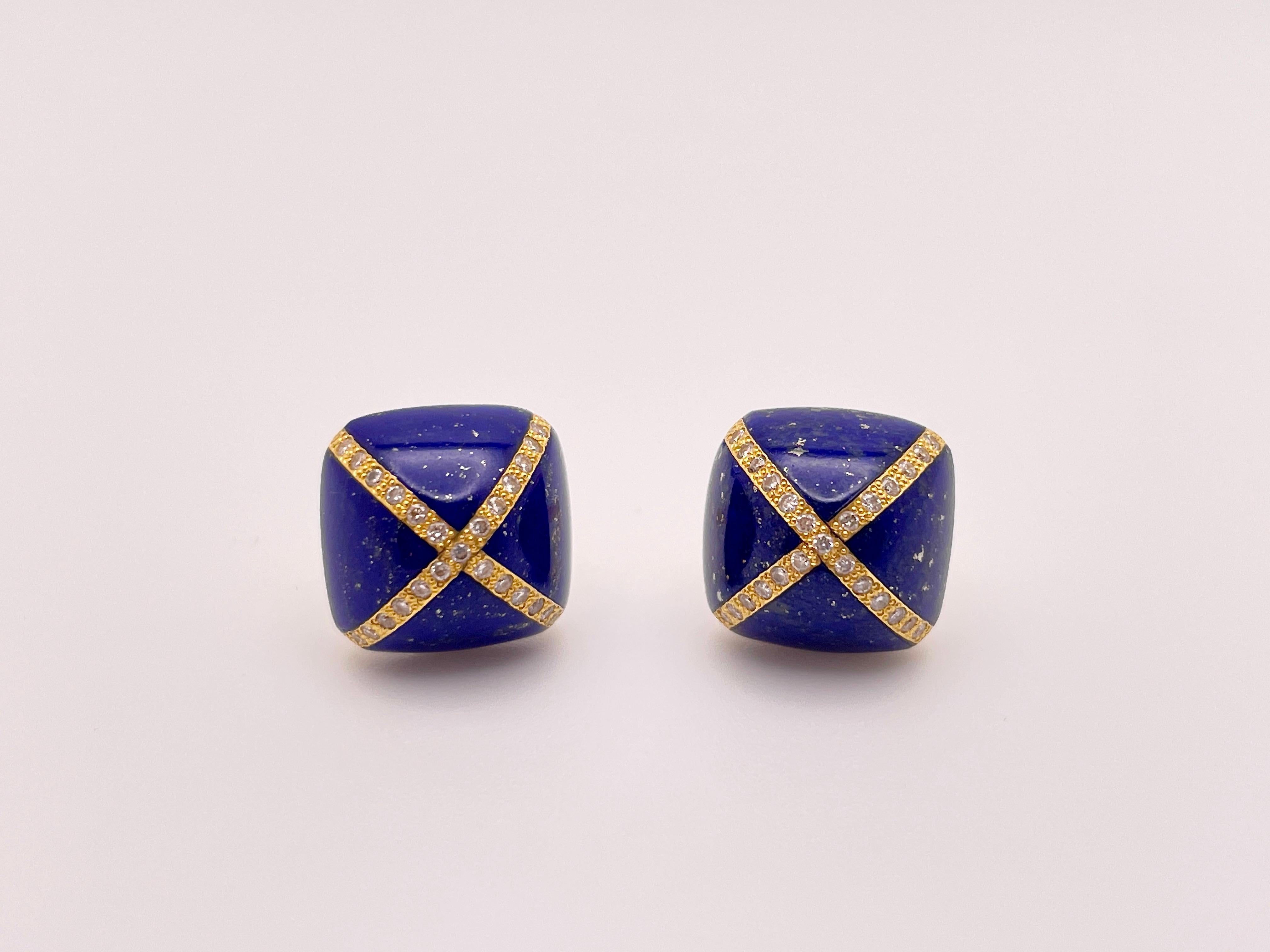 An original pair of 18K yellow gold lapis lazuli and diamond dome earrings. Circa 1930's, these magnificent earrings features an X shape of diamonds across the surface of the stone, totaling to 50 round single cut diamonds between both earrings.