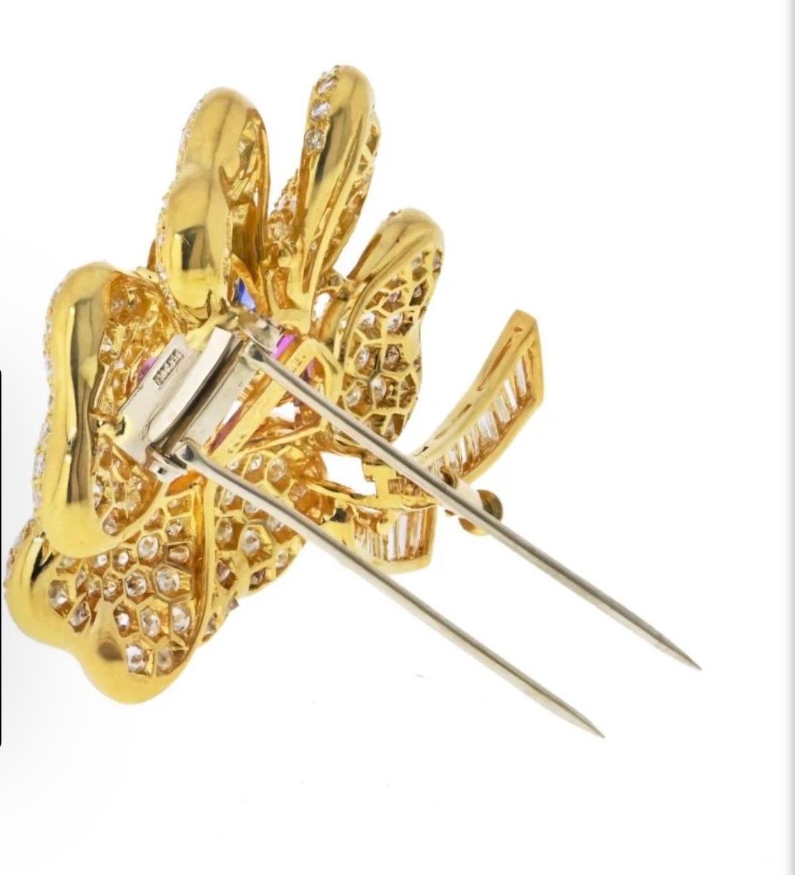 Description
18K Yellow Gold Diamond Multicolor Sapphire Flower Brooch 
Type: Brooches/pin
Metal: 18K Yellow Gold
Grams: 33.9
Approximate Diamond Weight: 13 Cts
Measurements: L: 2 inches long
Condition: Excellent.
Brand: ADLER
Other Details:
The