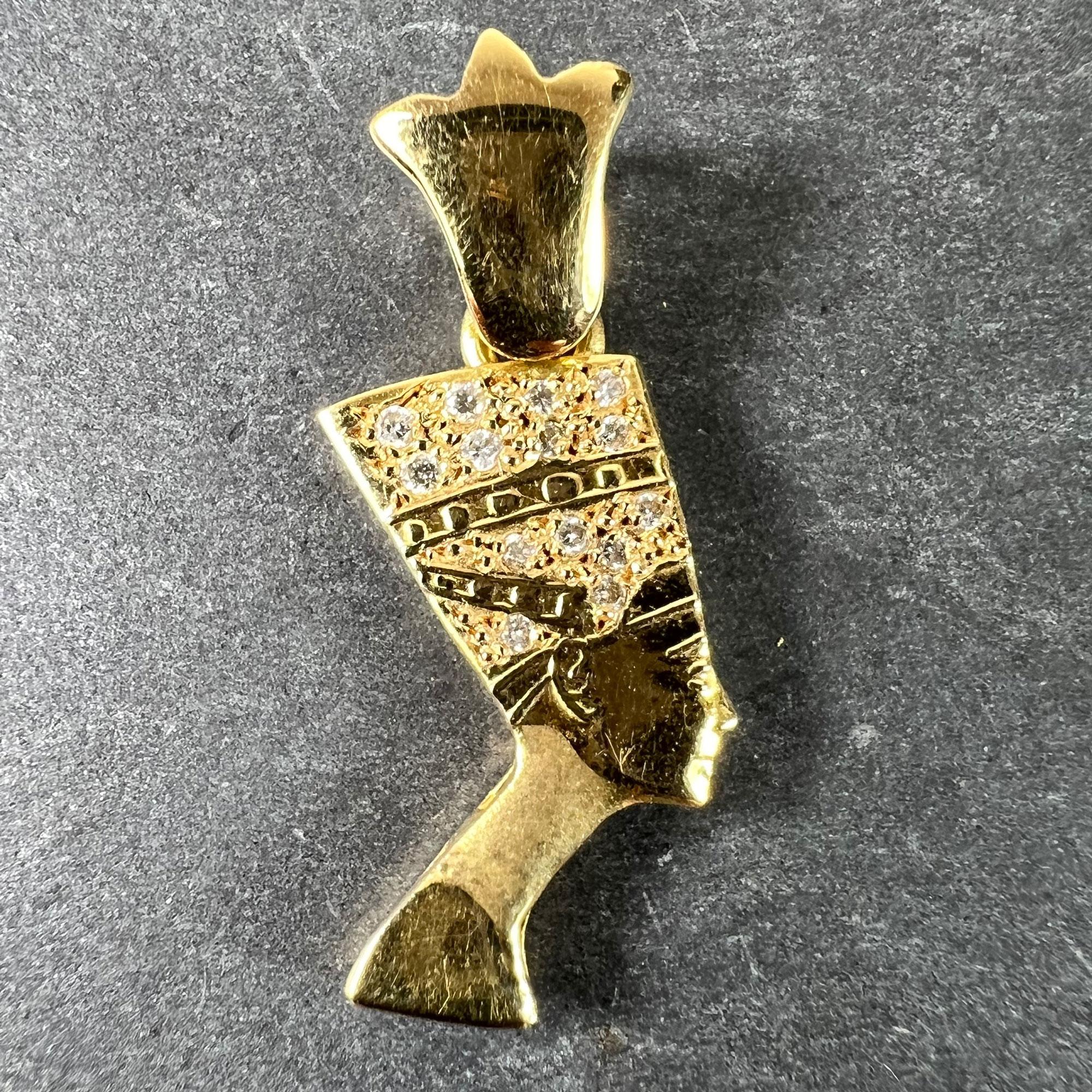 An 18 karat (18K) yellow gold charm pendant designed as the head of Nefertiti set with 14 round brilliant cut diamonds with an approximate total weight of 0.20 carats. Stamped with the French import mark for 18 karat gold along with Egyptian marks