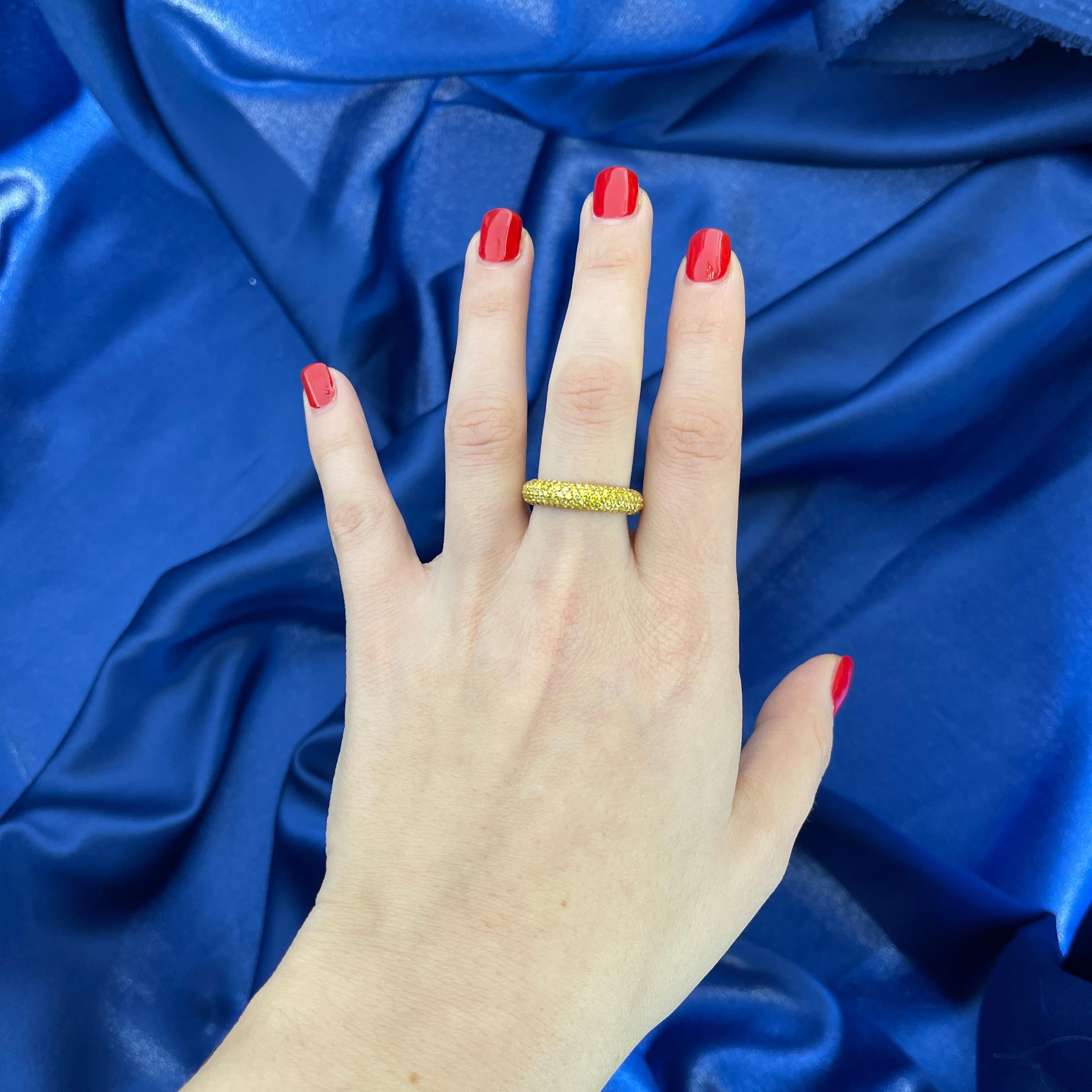 A refined expression of elegance, this 18K yellow gold band ring is entirely encrusted with a pavé of yellow diamonds totaling 1.96 carats. The seamless setting enhances the brilliance of each stone, creating a luminous surface of warm golden light.