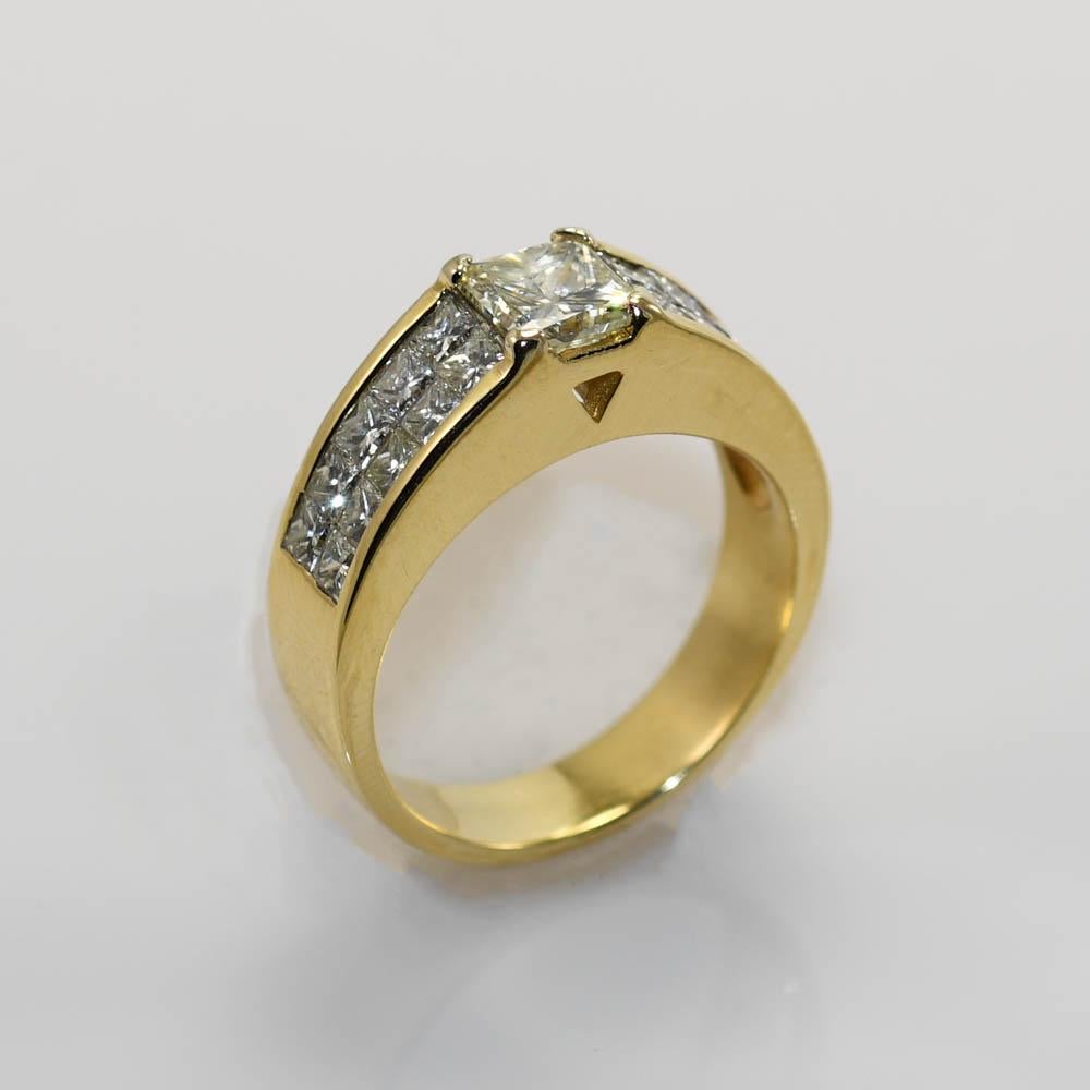 Ladies 18k yellow gold and diamond ring.
Tests 18k and weighs 8.3 grams.
The center diamond is a princess cut, 1.00 carats, K, L, M color range, Si2 clarity, good cut.
The side diamonds are princess cuts, 1.00 total carats, G, H, i color range, Vs