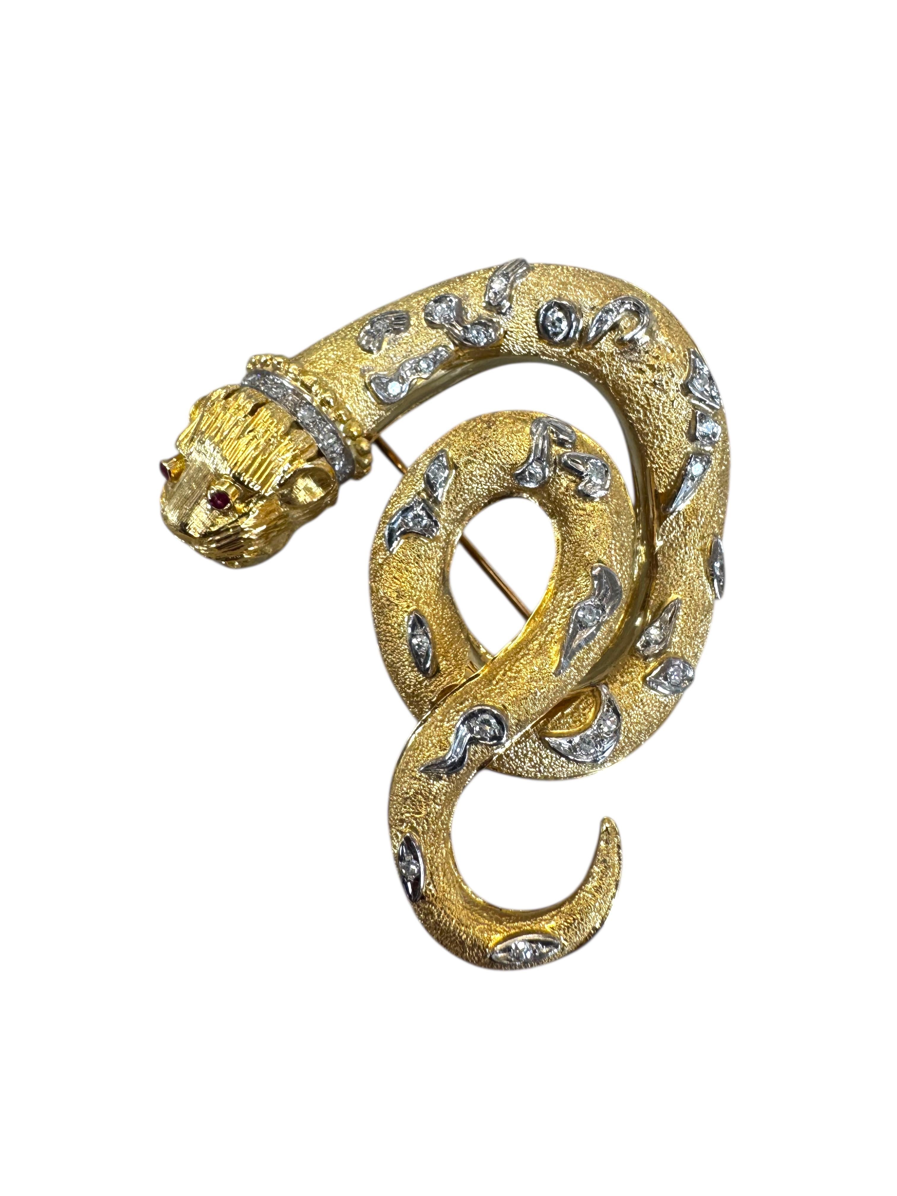 Eine auffällige und skulpturale Vintage-Brosche aus reich strukturiertem 18-karätigem Gelbgold in Form einer gewundenen Schlange mit einem löwenähnlichen Kopfmotiv. Der Kopf ist fein graviert und mit zwei lebhaften Rubinen im Rundschliff als Augen