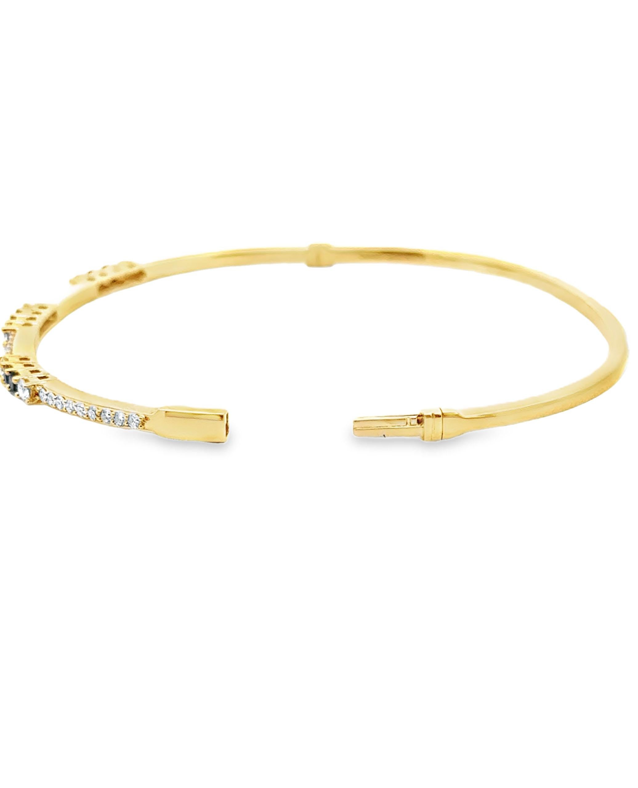 18K yellow gold bangle with 6 round faceted sapphires weighing 0.37 carats total and 36 round brilliant-cut diamonds weighing 0.65 carats total.