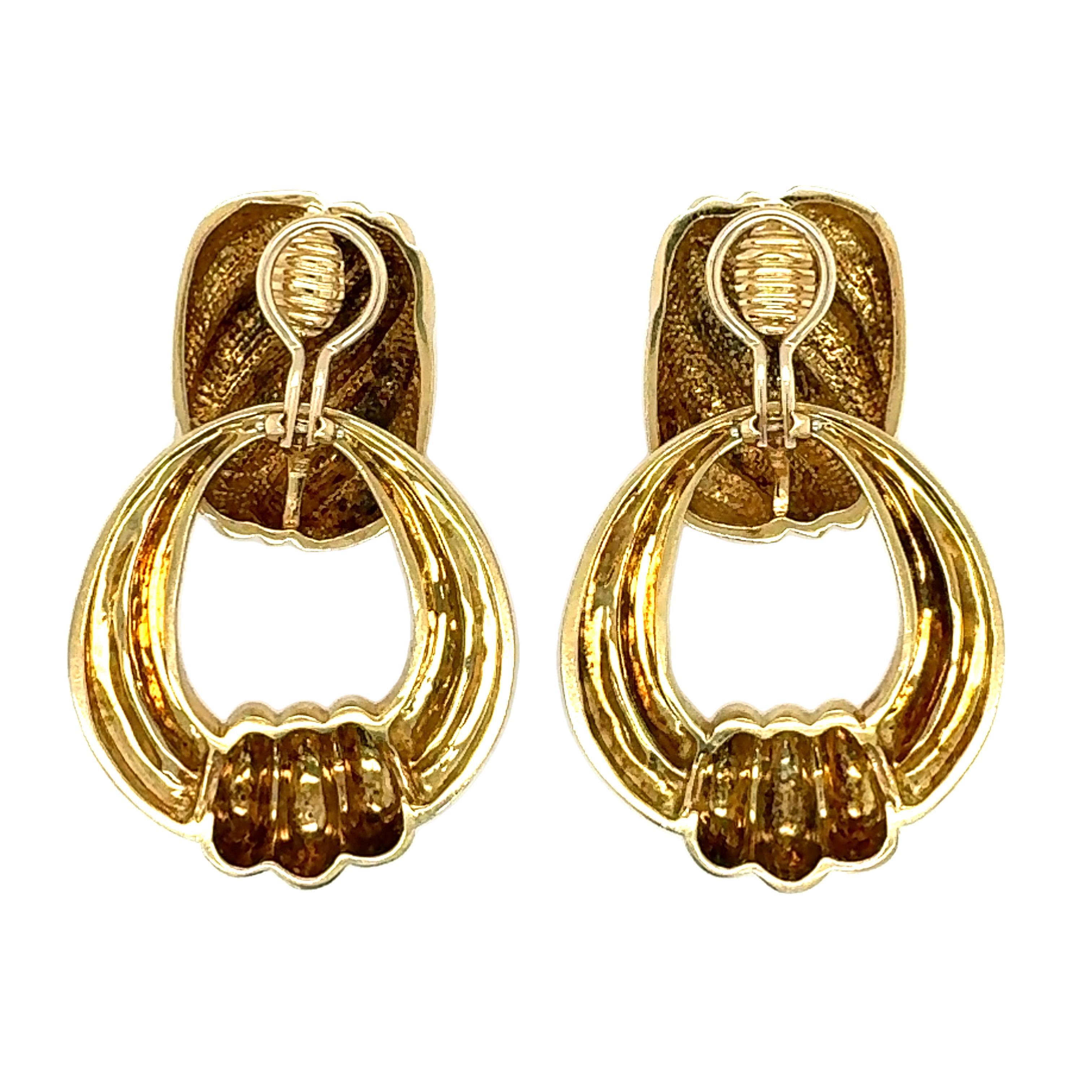These luxurious 18K yellow gold door knocker earclips combine vintage sophistication with functional versatility, crafted in a ribbed gold finish that exudes the bold style of the 1970s. Measuring a striking 54 mm in total length, the earrings