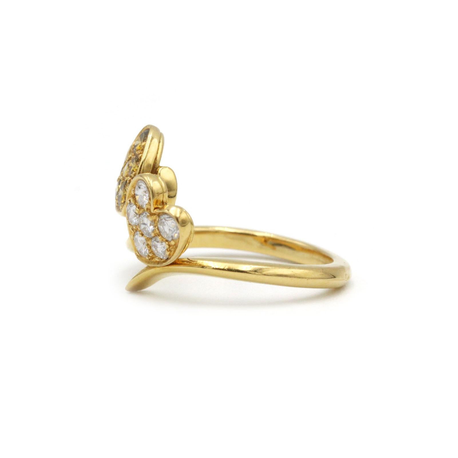 Abbraccia il romanticismo e l'eleganza moderna con questo squisito anello a doppio cuore in oro giallo 18 carati, caratterizzato da una fascia a vortice che avvolge delicatamente due motivi a cuore. Un cuore è tempestato di sei diamanti bianchi