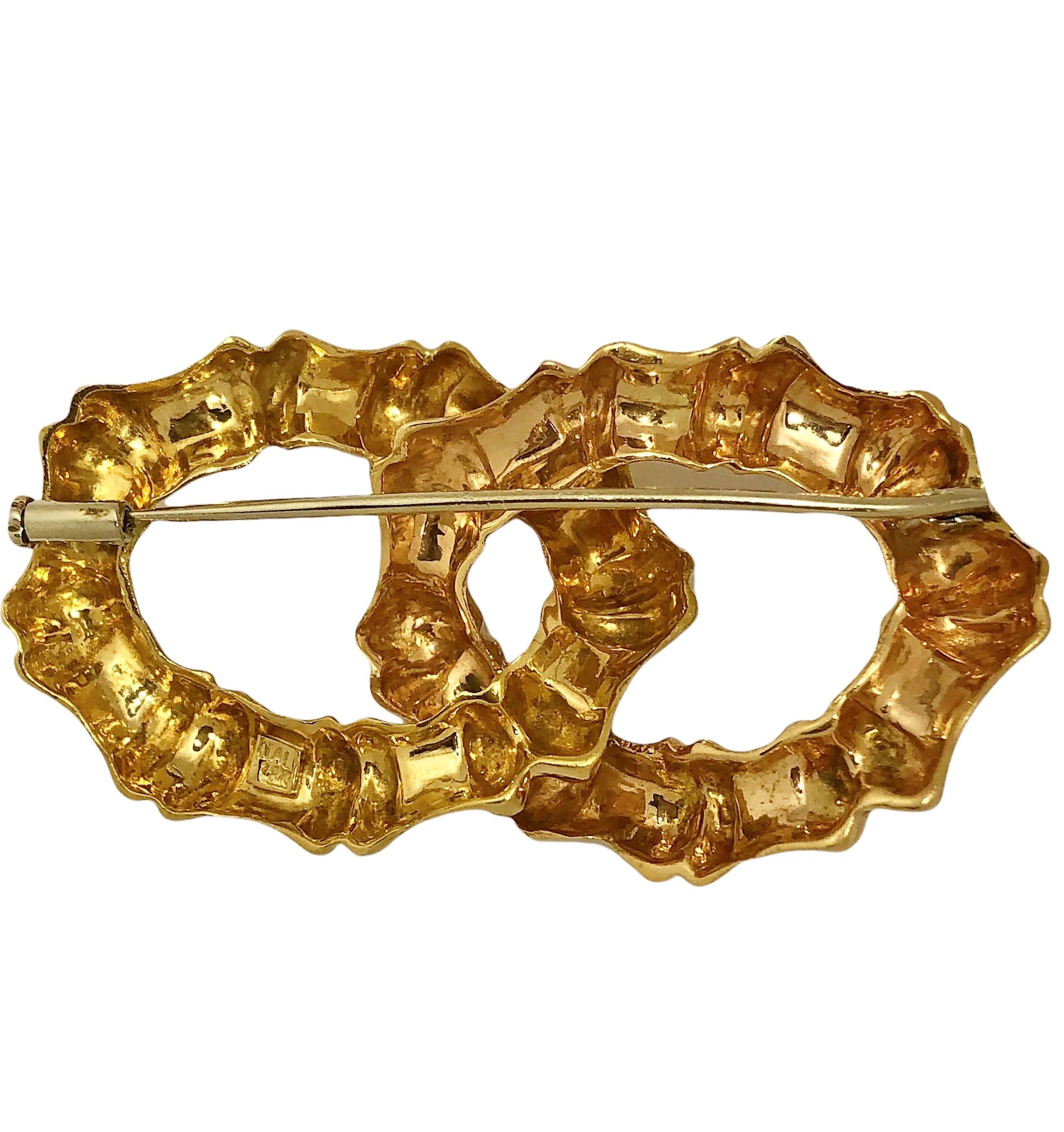 This lovely mid-20th century Italian bamboo link motif brooch consists of two Florentine and high polish finish, intertwined  bamboo links.  It is a very versatile size, measuring 2 1/4 inches in length by 1 1/8 inches in width, and is substantial