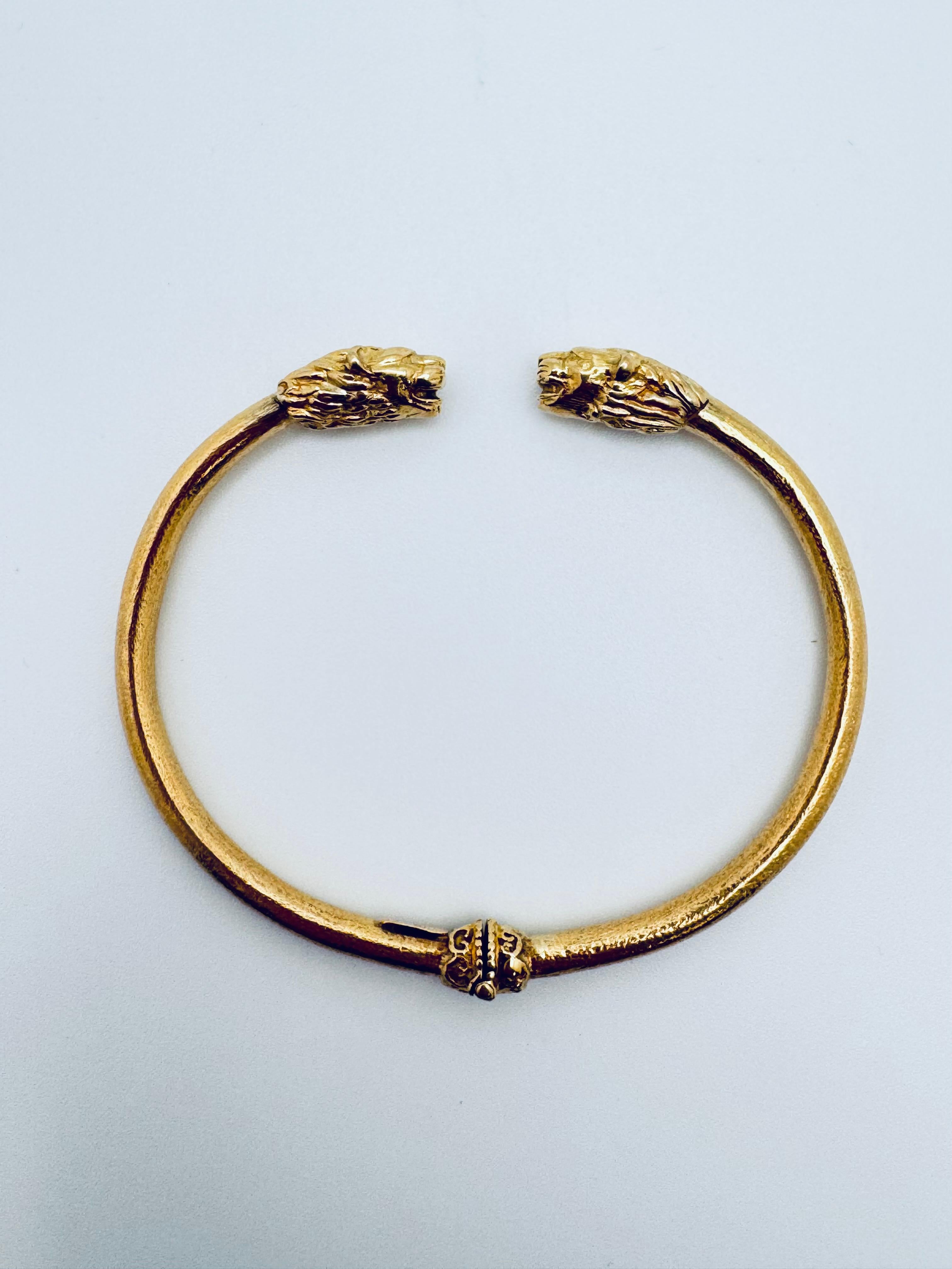 Dieser elegante Armreif mit doppeltem Löwenkopf wurde fachmännisch aus reichem 18-karätigem Gelbgold gefertigt und mit einer 750er-Marke für Reinheit und Authentizität versehen. Das Armband zeigt zwei fein detaillierte Löwenköpfe, die sich