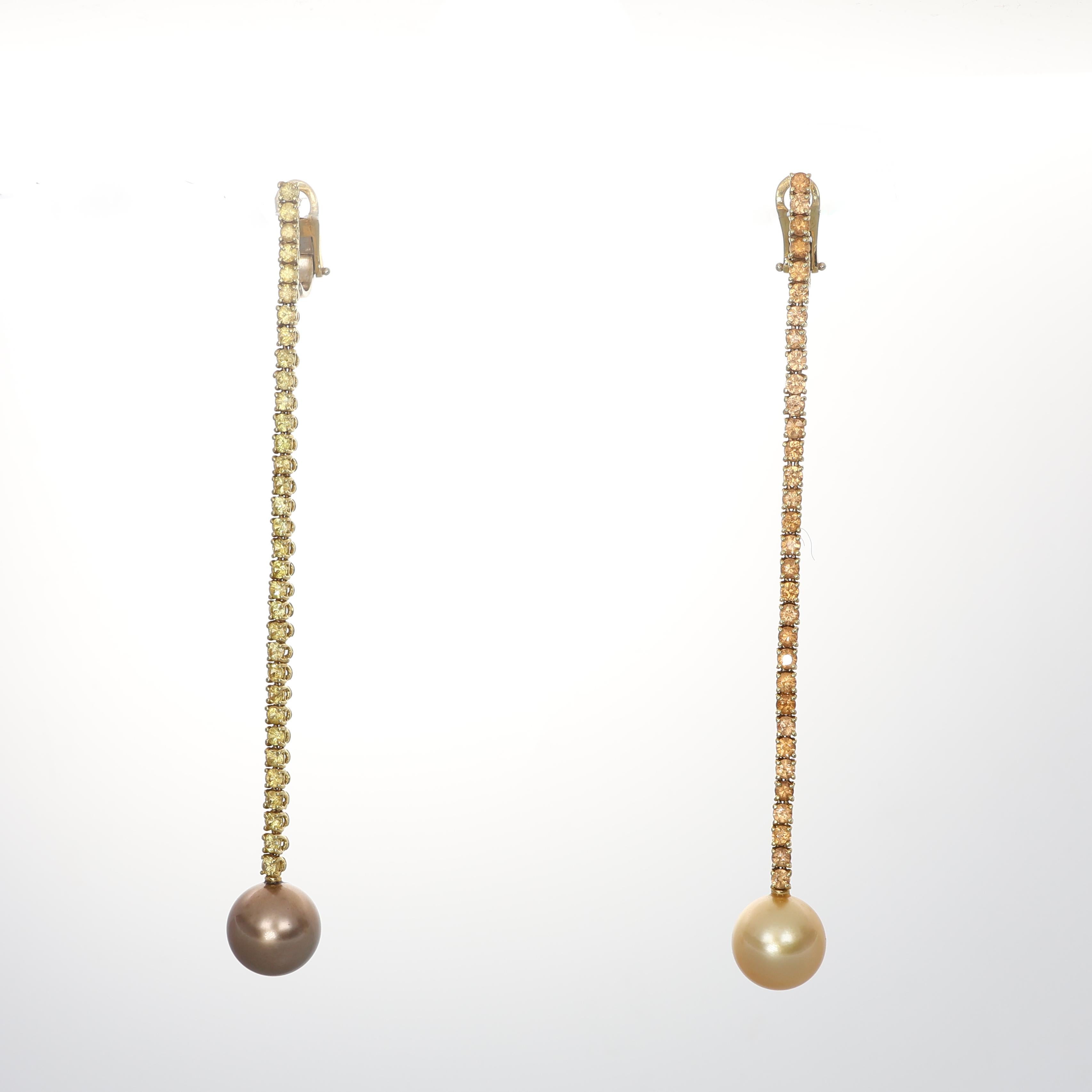 Elegant 18K yellow gold drop earrings adorned with a refined line of natural yellow sapphires, totaling 2.25 carats. The sophisticated design is completed by two exquisite pearls in chocolate and gold tones, adding a luxurious contrast. A timeless