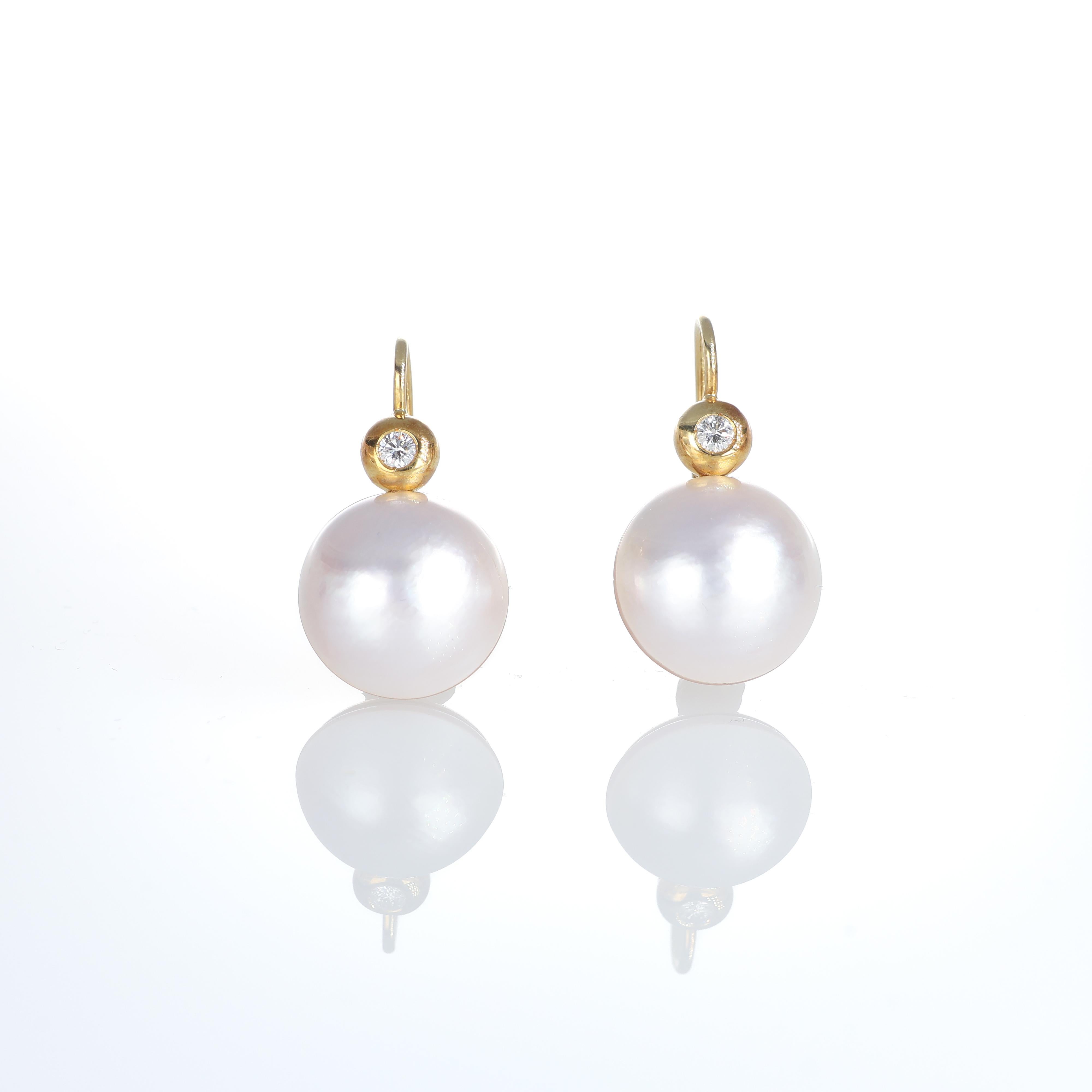 Timeless elegance defines these drop earrings in 18K yellow gold, featuring luminous pearls accentuated by a delicate diamond detail. The warm gold setting enhances the natural beauty of the pearls, creating a refined and versatile design.

Key
