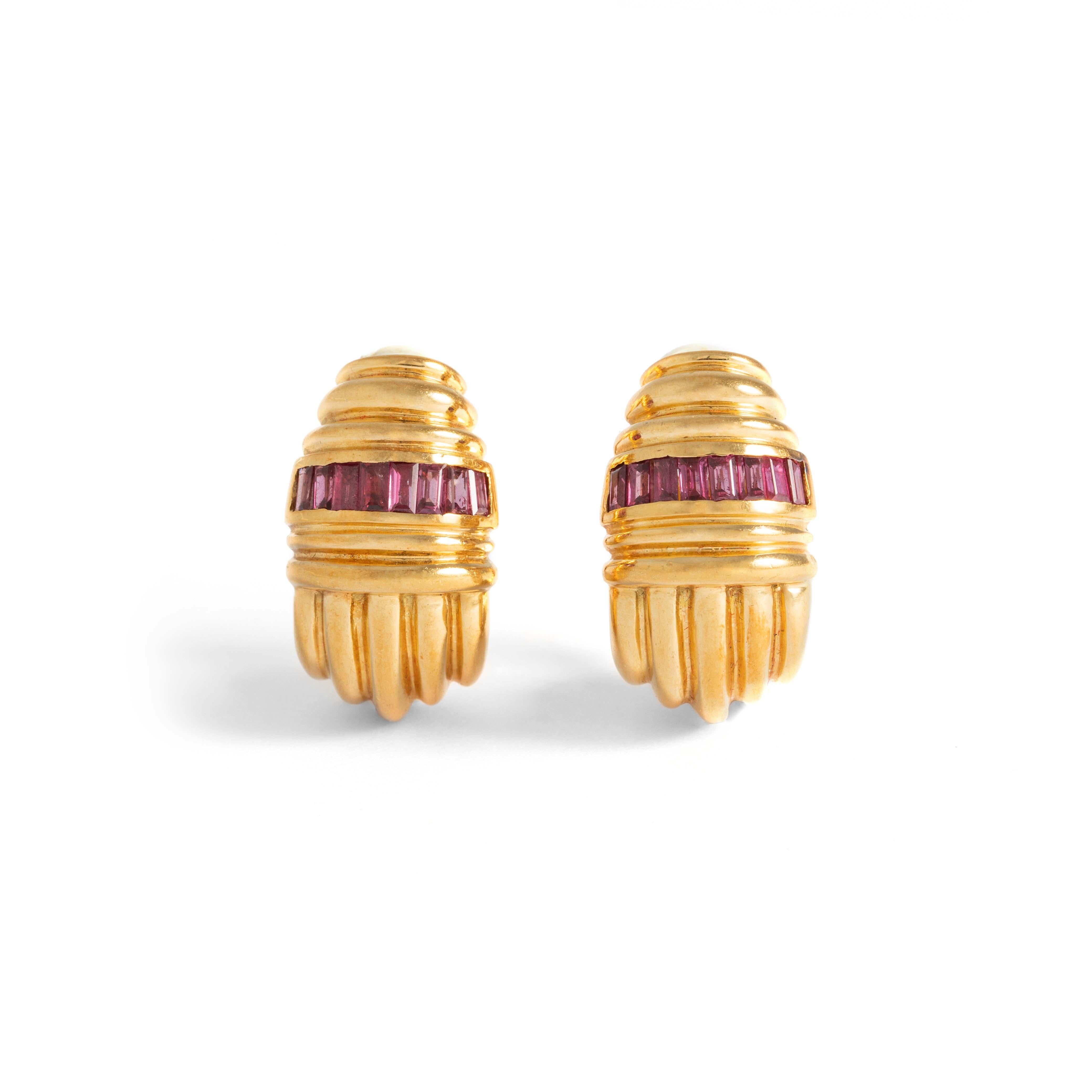 Pair of 18K yellow gold earrings respectively set with calibrated red stones.
Dimensions: 
2.80 centimeters x 1.50 centimeters.
Gross weight: 30.92 grams.