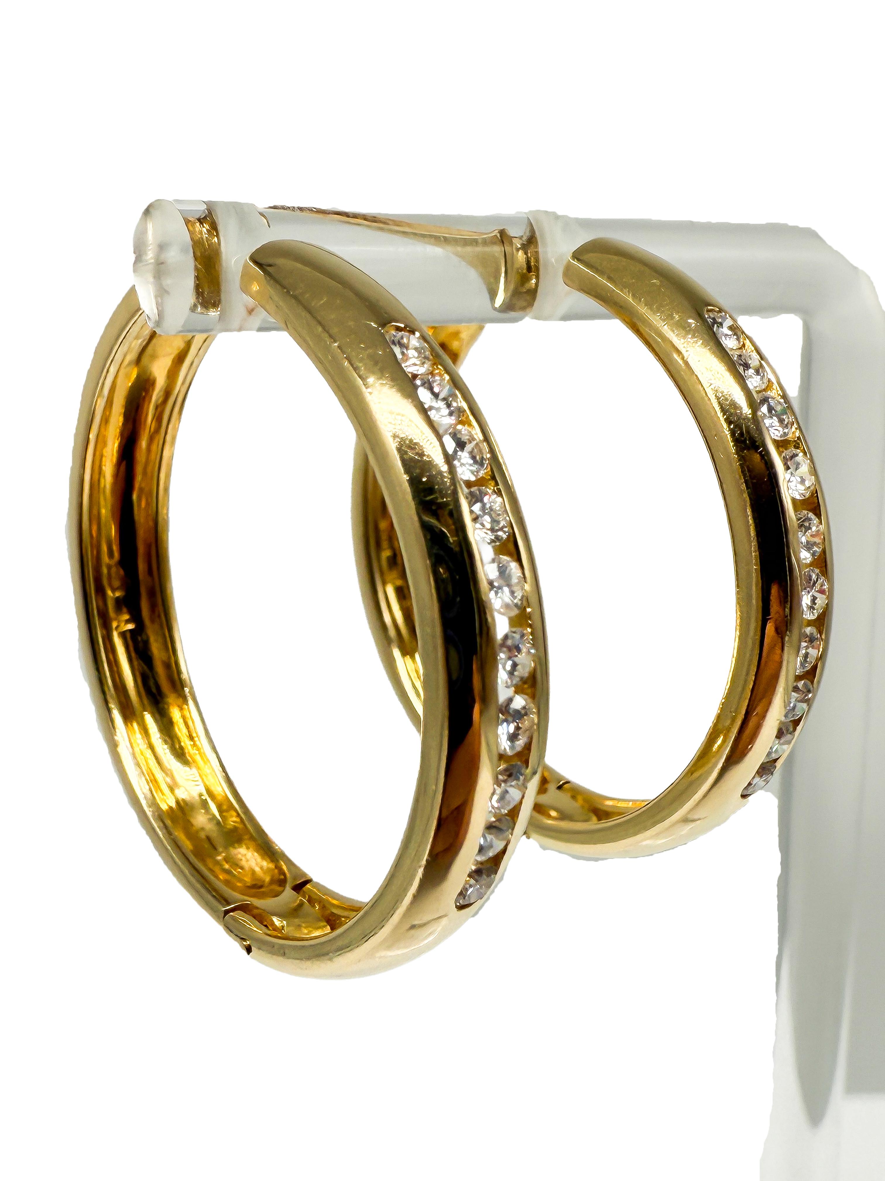 Estos elegantes pendientes de oro amarillo de 18 quilates combinan un diseño clásico con un brillo resplandeciente, añadiendo un acento de estilo para cualquier ocasión. Con un diámetro de 3 cm, los pendientes son sutilmente llamativos y se asientan