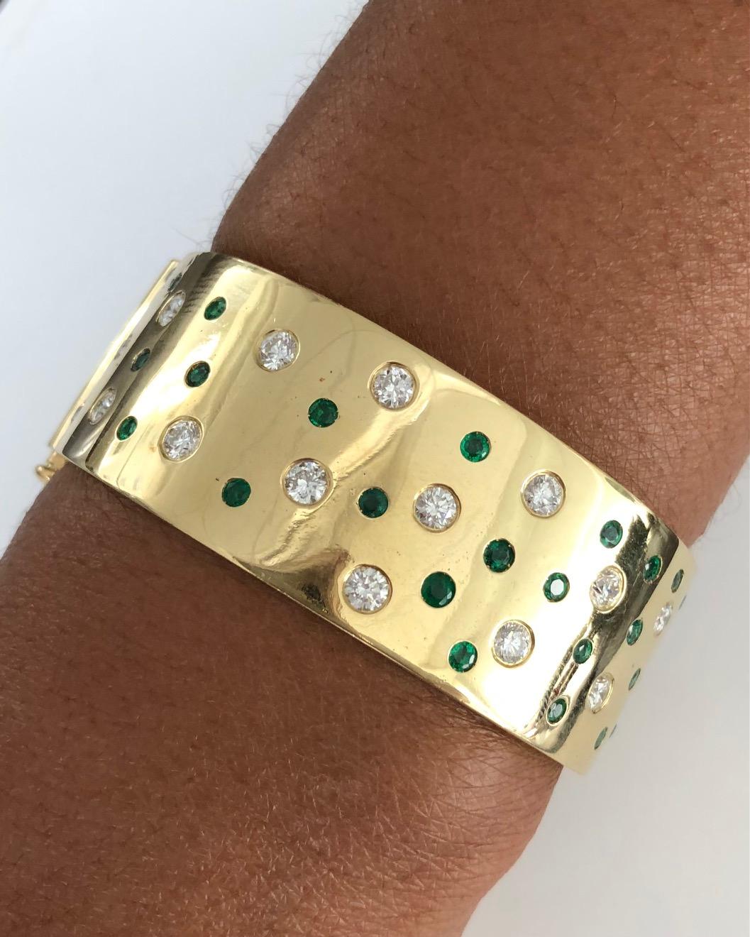 Fashionable wide Bangle Bracelet, made in 18K Yellow Gold, set with a combination of Diamonds( 2.61 carats ) and Emeralds ( 1.60 carats ), featuring our easy push-button opener.
Bracelet width: 7/7 inch ( 2.3 CM )

We design and manufacture our