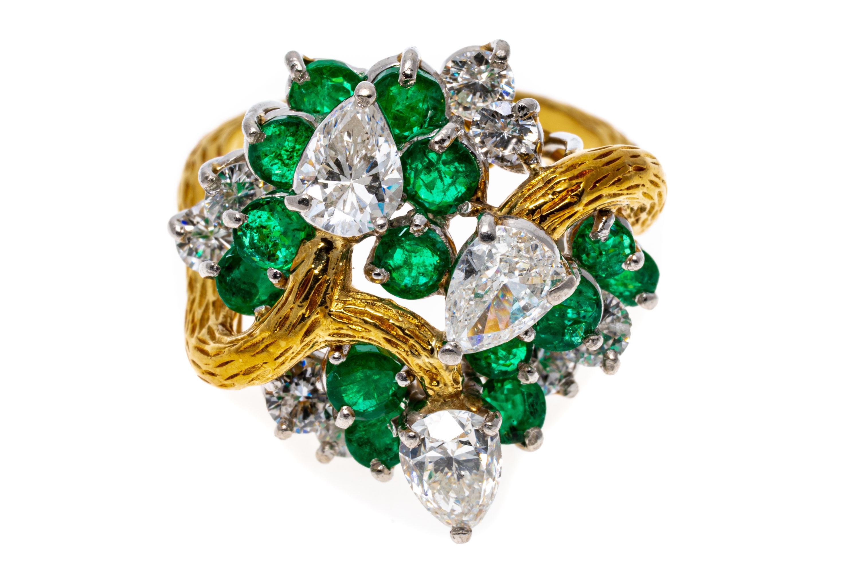 18k yellow gold ring. This stunning cluster ring is a bypass swirl of round faceted, bright green color emeralds approximately 1.56 TCW, scattered among round brilliant cut diamonds, approximately 0.78 TCW. Swirled among the round emeralds and