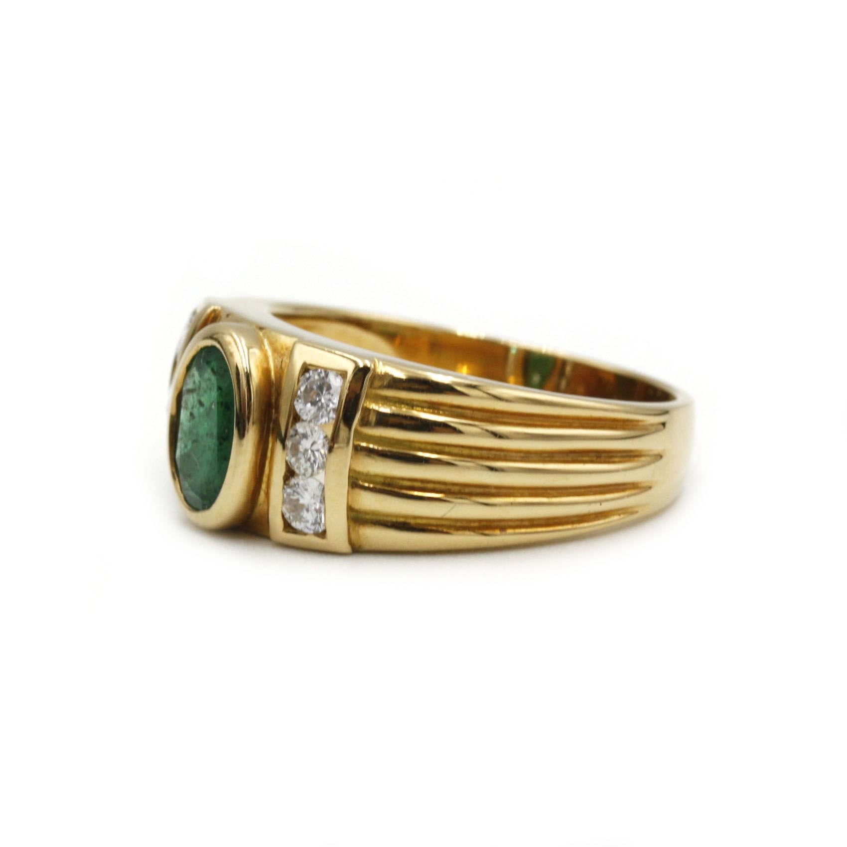 Cette élégante bague pour femme est réalisée en somptueux or jaune 18 carats (750‰) et présente une vive émeraude de taille ovale d'environ 0,90 carat, délicatement sertie en son centre. Sur chaque épaule, trois diamants taille brillant (six au