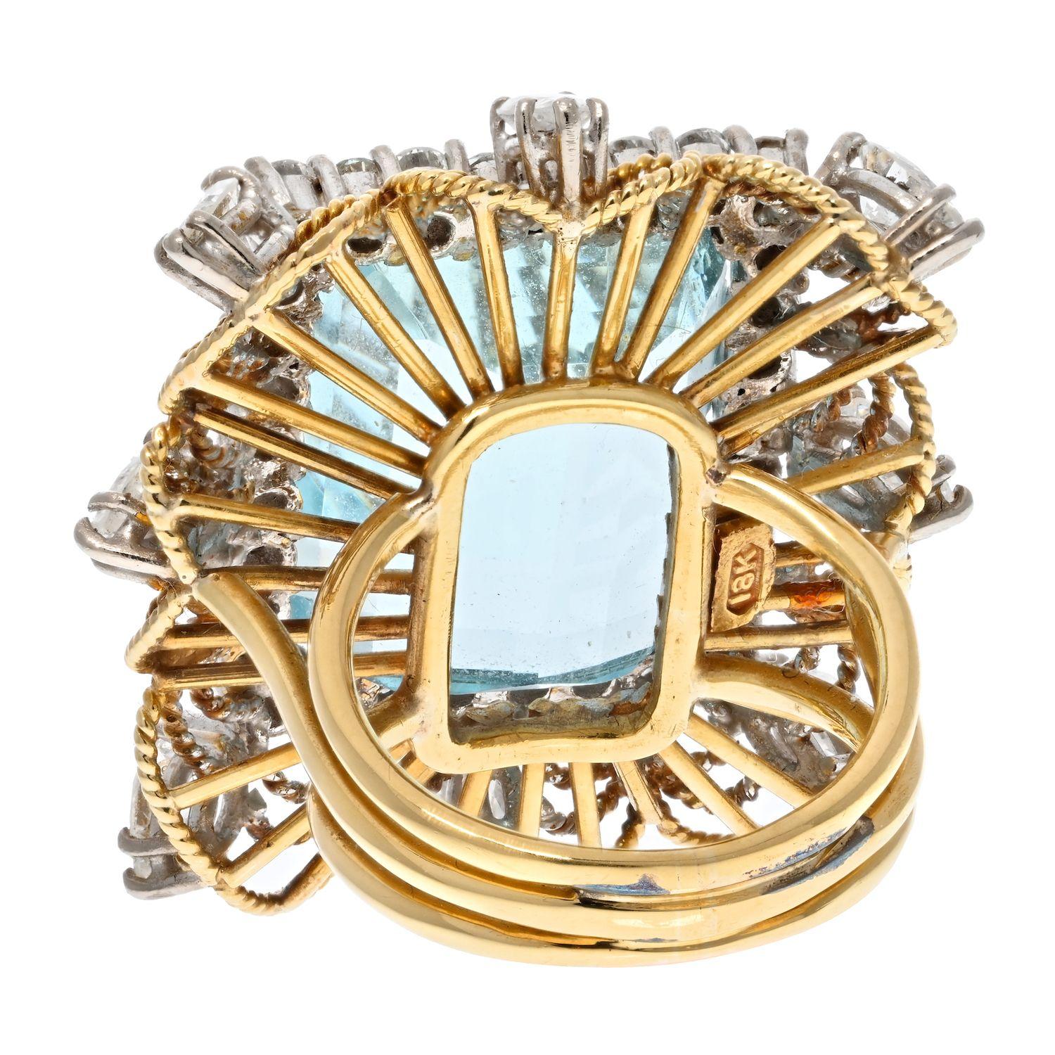 An estate ring crafted in 18k yellow gold and platinum with a stunning light blue Aquamarine in the center with a diamond surround. 
Further accented with marquise cut diamonds on an openwork twisted gold wire frame. 
Aquamarine measures: 18mm x