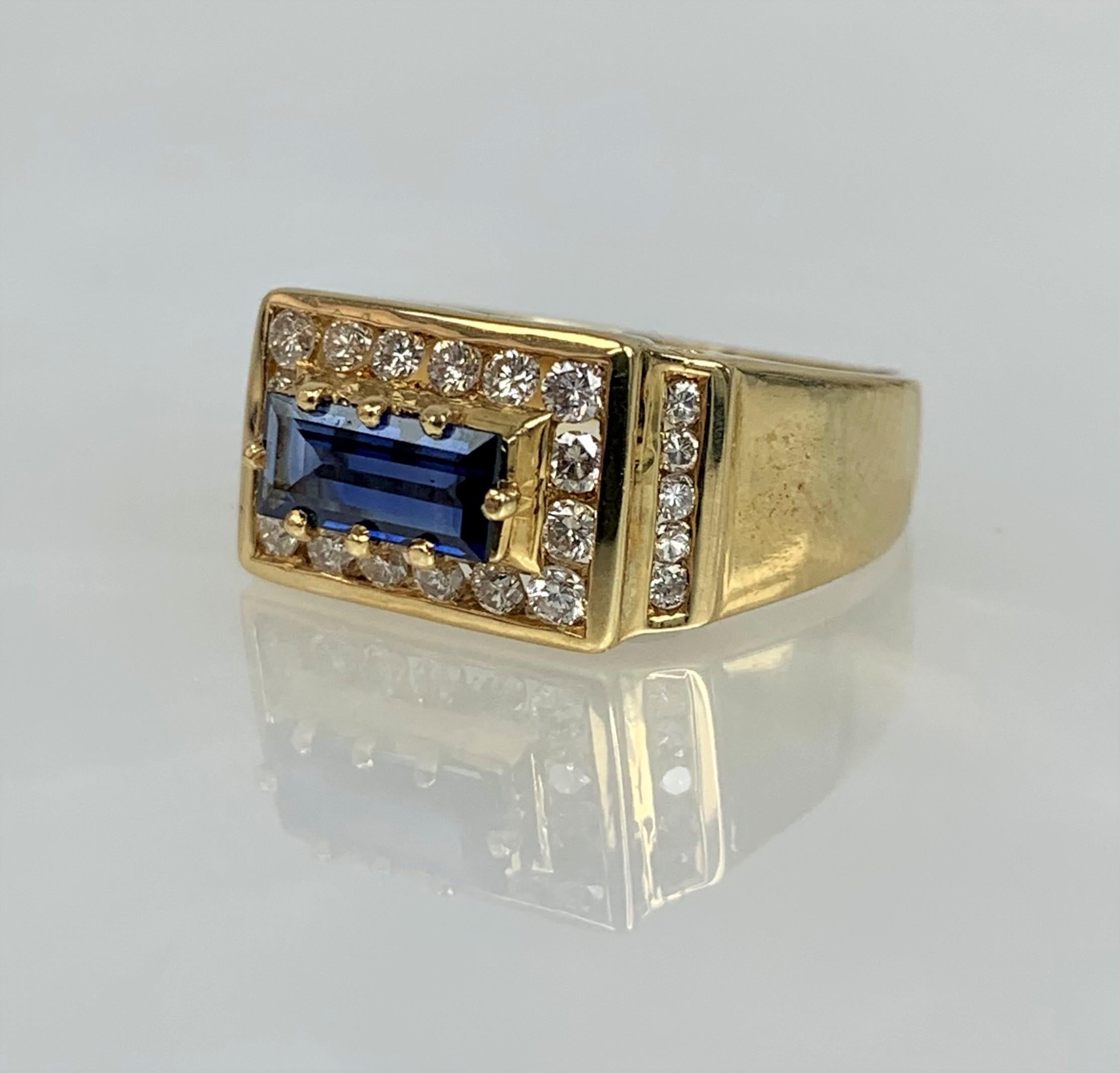 An unusual and luxurious vintage sapphire ring featuring an emerald cut center stone weighing 0.69 carats set in an east-west orientation while accented by 0.53 carats of sparkling white diamonds with channel setting in solid 18k yellow