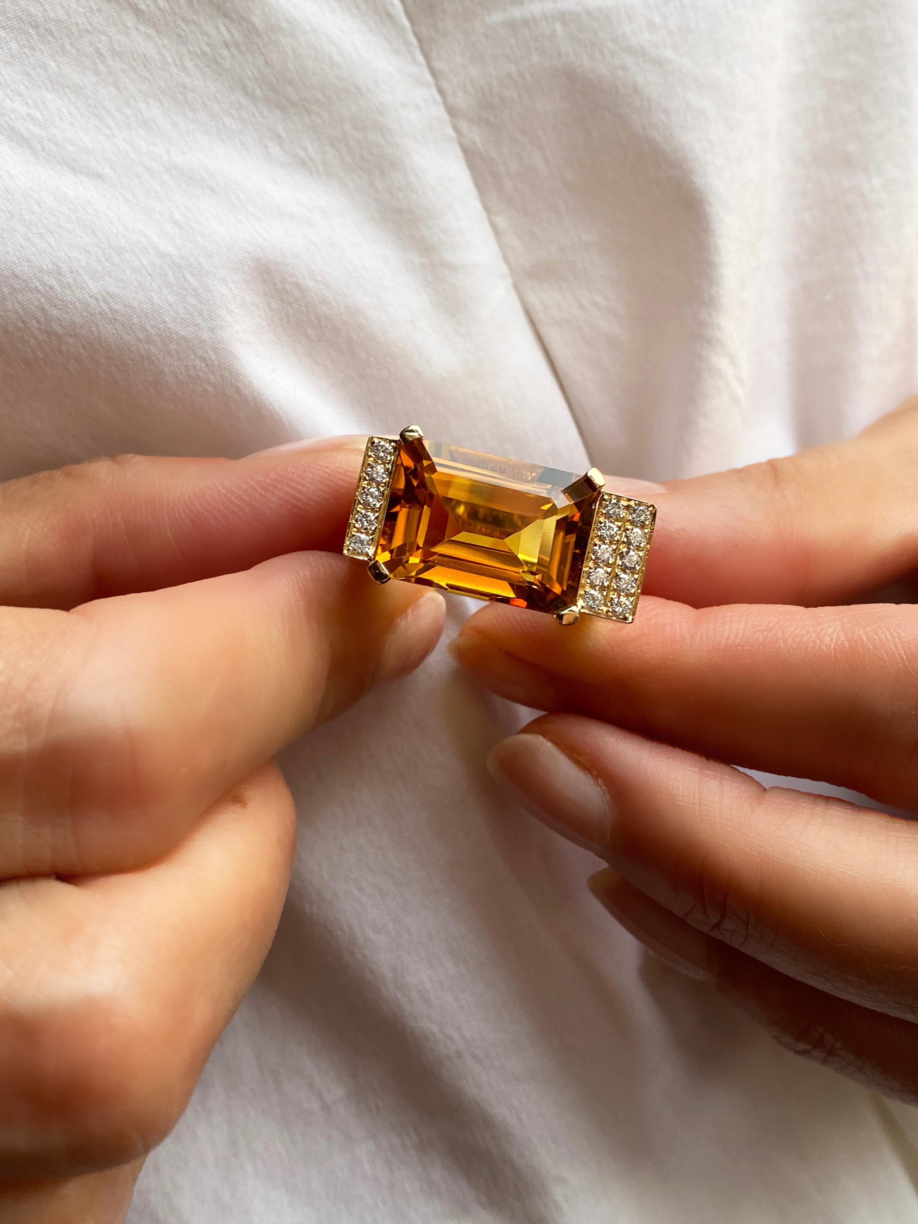 The Rossella Ugolini Design 18K Yellow Gold Emerald Cut Citrine and 0.30 Carats White Diamonds Deco Style Cocktail Ring is a truly unique piece of jewelry. The centerpiece of the ring is an emerald-cut Citrine, featuring a rich, intense yellow hue.