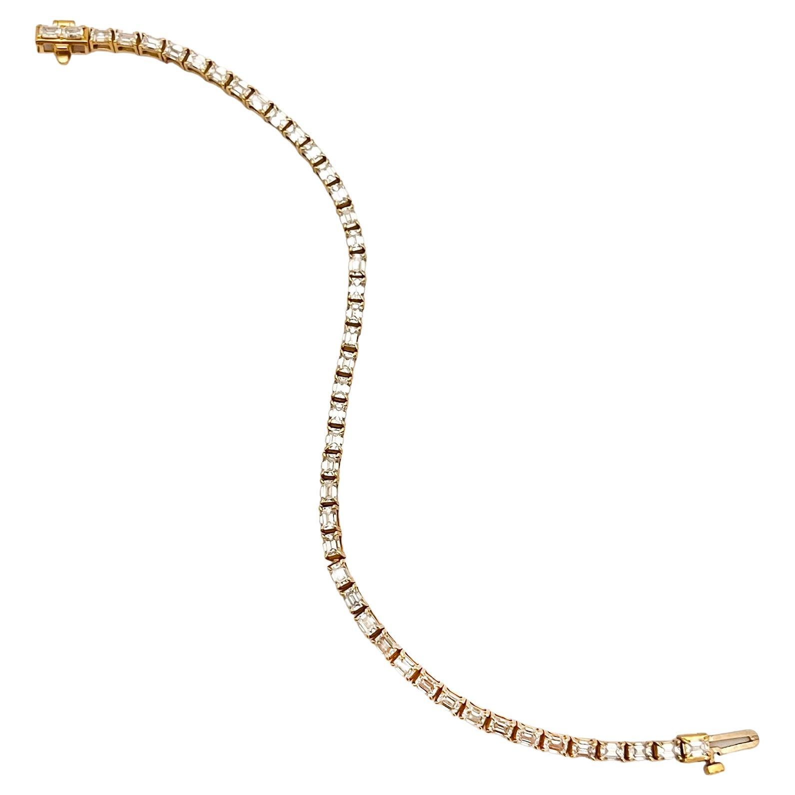Line bracelet, featuring colorless emerald-cut diamonds set in polished 18k yellow gold.  45 diamonds weighing 4.90 total carats (D-E color, VS1-VS2 clarity).  6.5