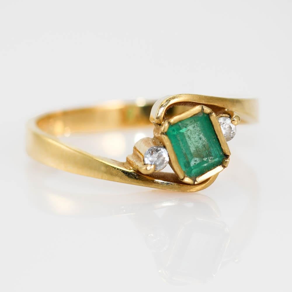 18k Yellow Gold Emerald & Diamond Ring.
The Emerald Measures 4.5mm x 3.5mm.
Stamped 18k, weighs 3.1gr.
Size 7 1/2.
Can be sized for additional fee.