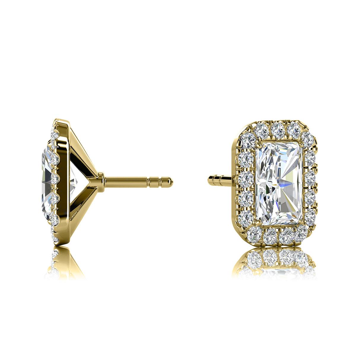 Ces délicates boucles d'oreilles comportent deux diamants de forme émeraude d'un poids total d'environ 1,00 carat (6 mm x 4 mm) entourés d'un halo de 30 diamants ronds de taille brillant parfaitement assortis d'un poids total d'environ 0,46 carat.