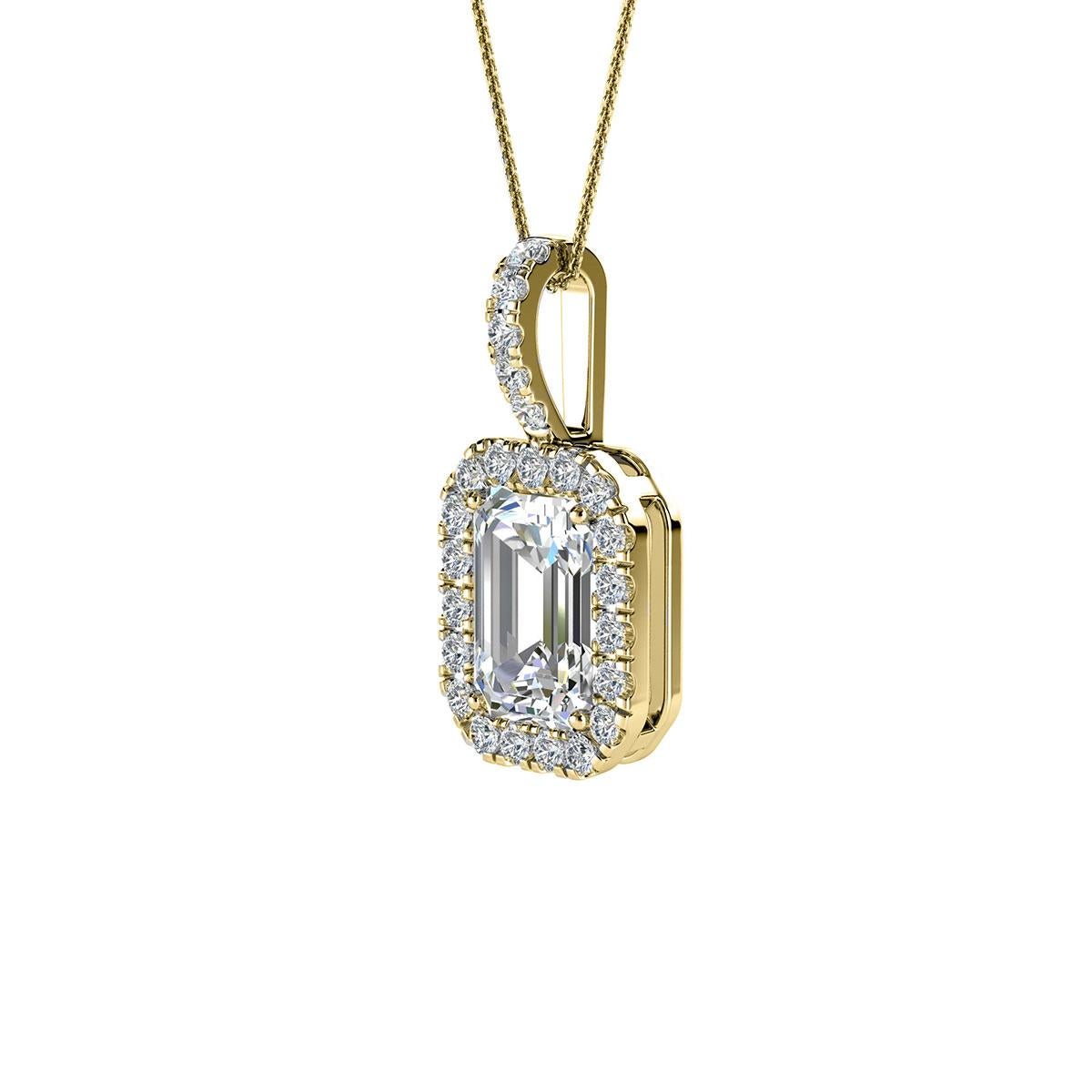 Ce délicat pendentif présente un diamant en forme d'émeraude d'un poids total d'environ 0,65 carat (6 mm x 4 mm) entouré d'un halo de 23 diamants ronds brillants parfaitement assortis d'un poids total d'environ 0,12 carat. Le pendentif mesure 15 mm