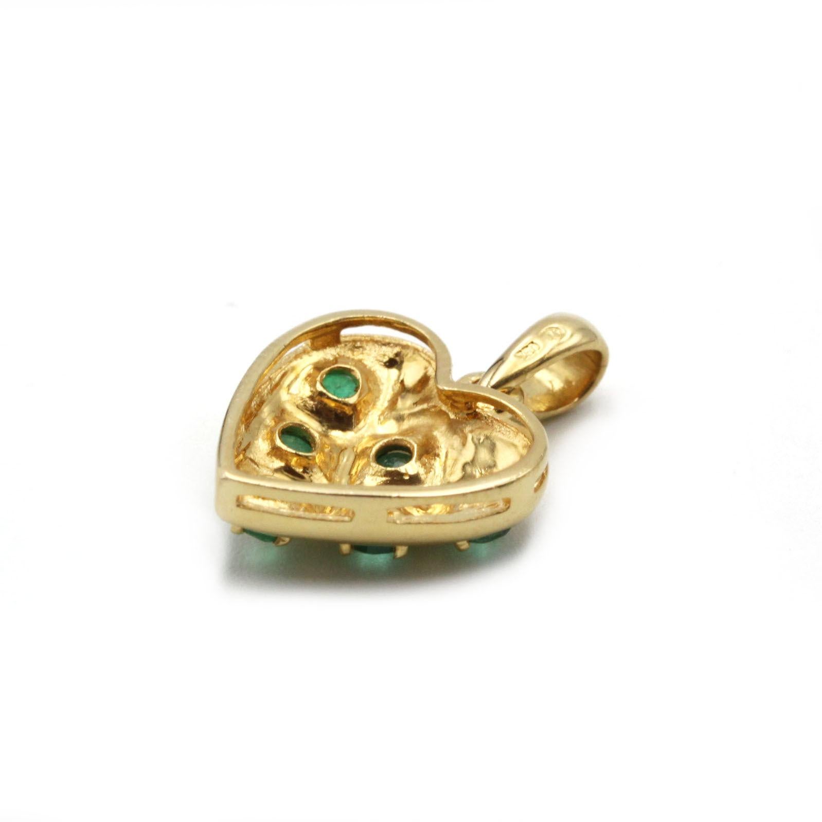 Célébrant à la fois la vitalité et le romantisme, ce pendentif en or jaune 18 carats est moulé dans un cœur doucement arrondi et ponctué de six émeraudes rondes lustrées d'une valeur totale d'environ 0,50 carat. Les pierres précieuses sont nichées