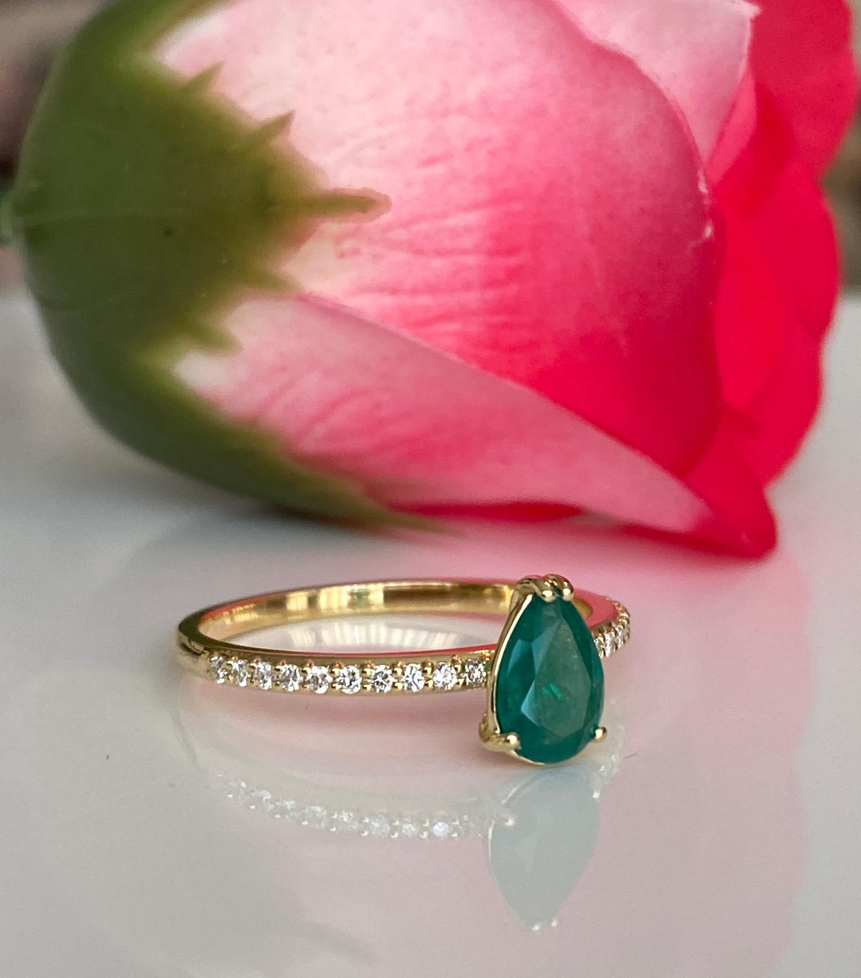 Une magnifique bague de fiançailles en or jaune 18 carats, dont la pièce maîtresse est une émeraude de 0,60 carat. La riche teinte verte de l'émeraude est magnifiquement complétée par des diamants d'accentuation étincelants, qui ajoutent de l'éclat