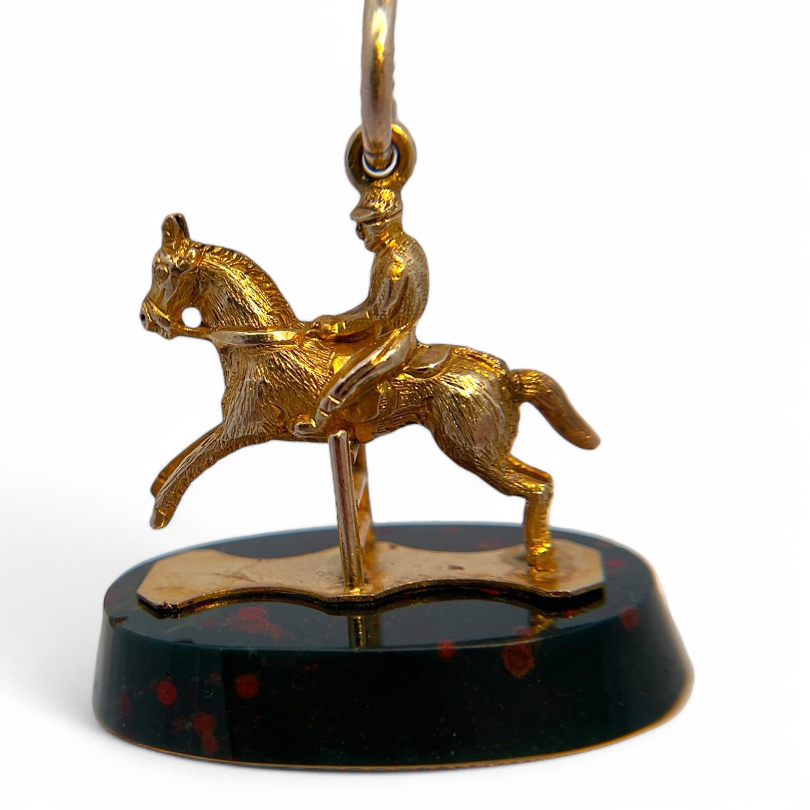 Tipo : Charm
Pietra: Opale
Metallo : Oro giallo 18k
peso: 11,85 g

Questo charm equestre finemente lavorato è realizzato in oro giallo 18 carati e presenta un cavallo e un cavaliere dettagliati su una base di opale lucido con ricche inclusioni