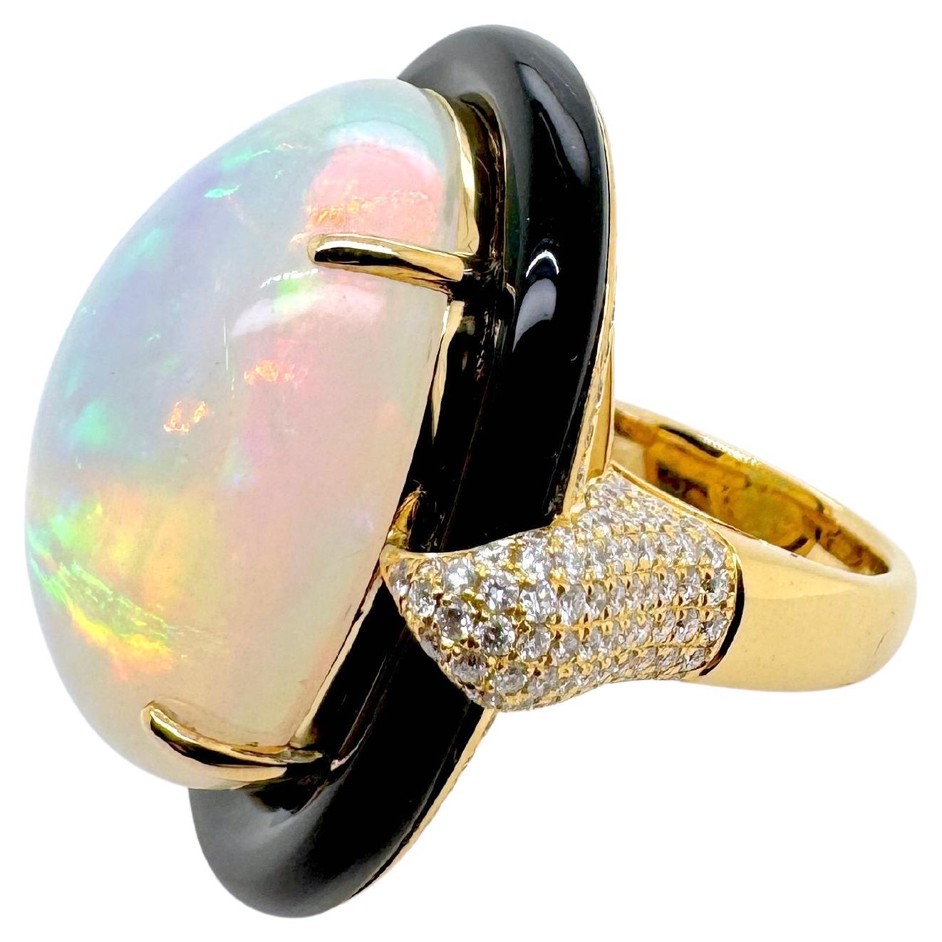 At the heart of this show stopping masterpiece lies an extraordinary Ethiopian opal, dramatically oversized and ablaze with an internal fire that dances in every color of the rainbow. Its mesmerizing play-of-color is boldly framed by a smooth black