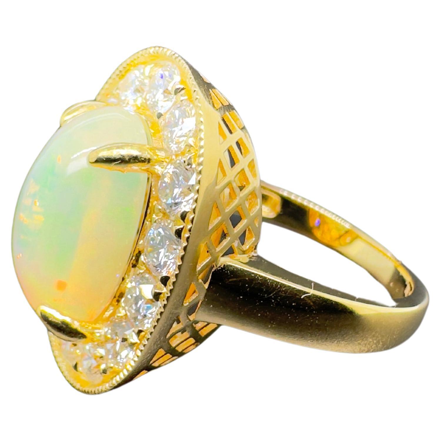 This gorgeous Ethiopian opal is set in 18k yellow gold round brilliant diamonds.  The opal displays orange and green flashes while the white brilliant diamonds accent the center stone.  The edges add a nice touch to finish out this classic ring