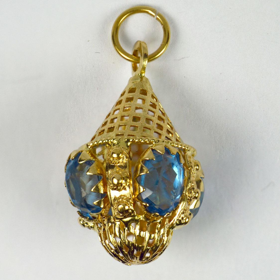 An 18 karat (18K) yellow gold charm pendant designed as an Etruscan pierced pendant set with blue paste. Stamped 750 for 18 karat gold and Italian manufacture.

Dimensions: 2.9 x 1.8 x 1.8 cm (not including jump ring)
Weight: 5.41 grams
