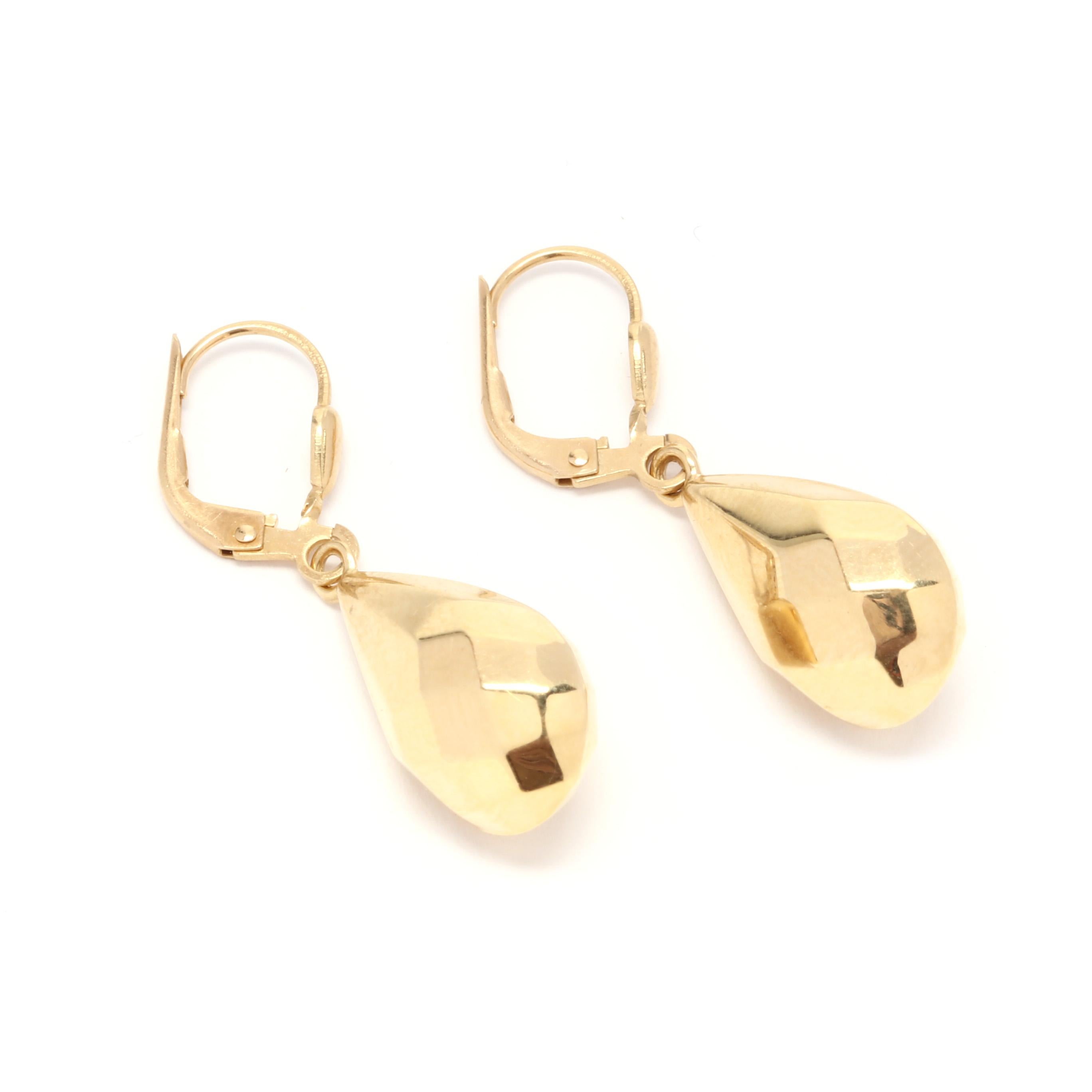 A pair of 18 karat yellow gold faceted tear drop dangle earrings. A puffed, faceted teardrop dangle design suspended from lever back closures.  

Length: 1 1/4 in.

Width: 7/16 in.

1.76 dwts.

* Please note that this is a vintage item and may show