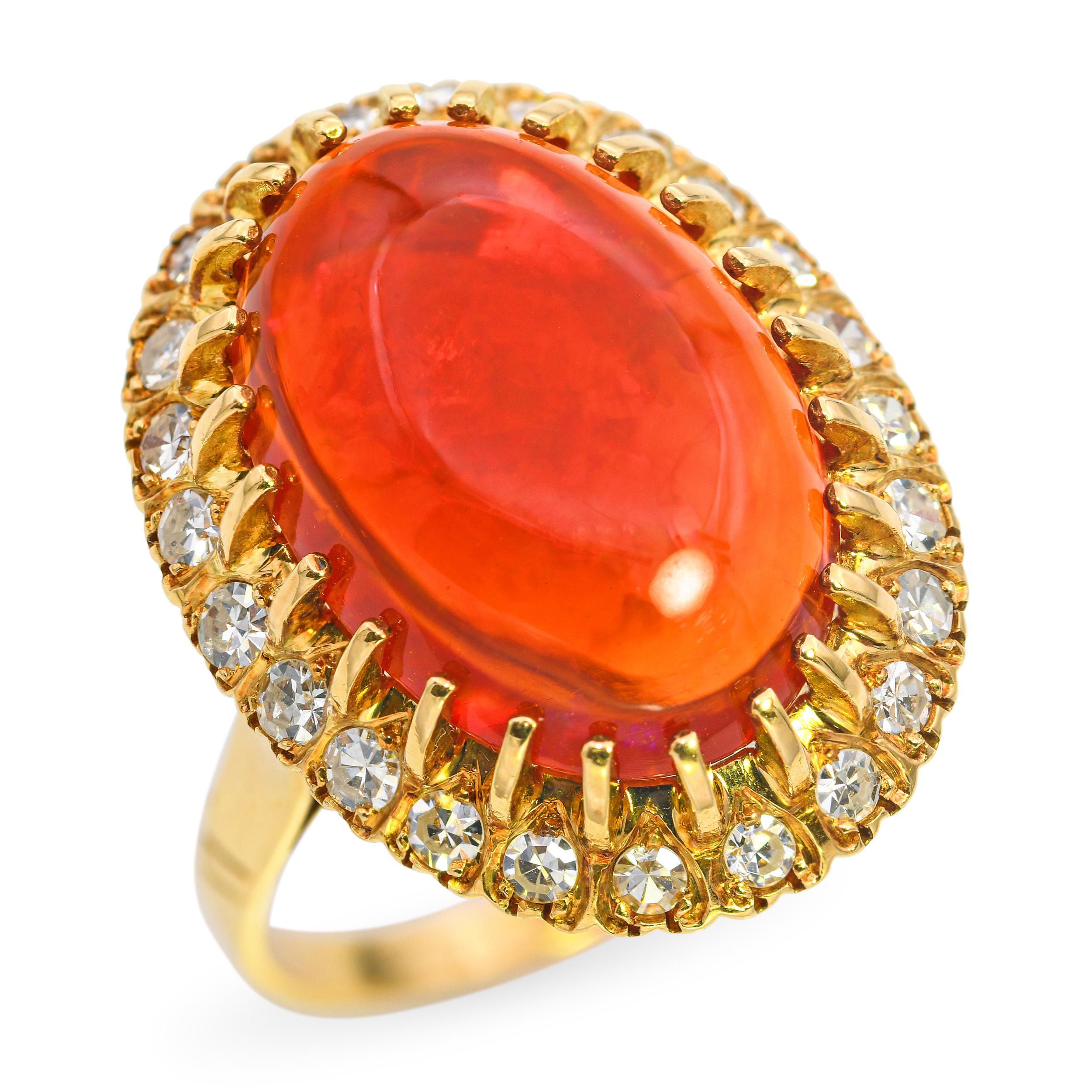 This striking ring is crafted in rich 18k yellow gold and features a vivid fire opal at its center, radiating intense orange and red hues characteristic of this rare and fiery gemstone. The opal is beautifully complemented by sparkling white
