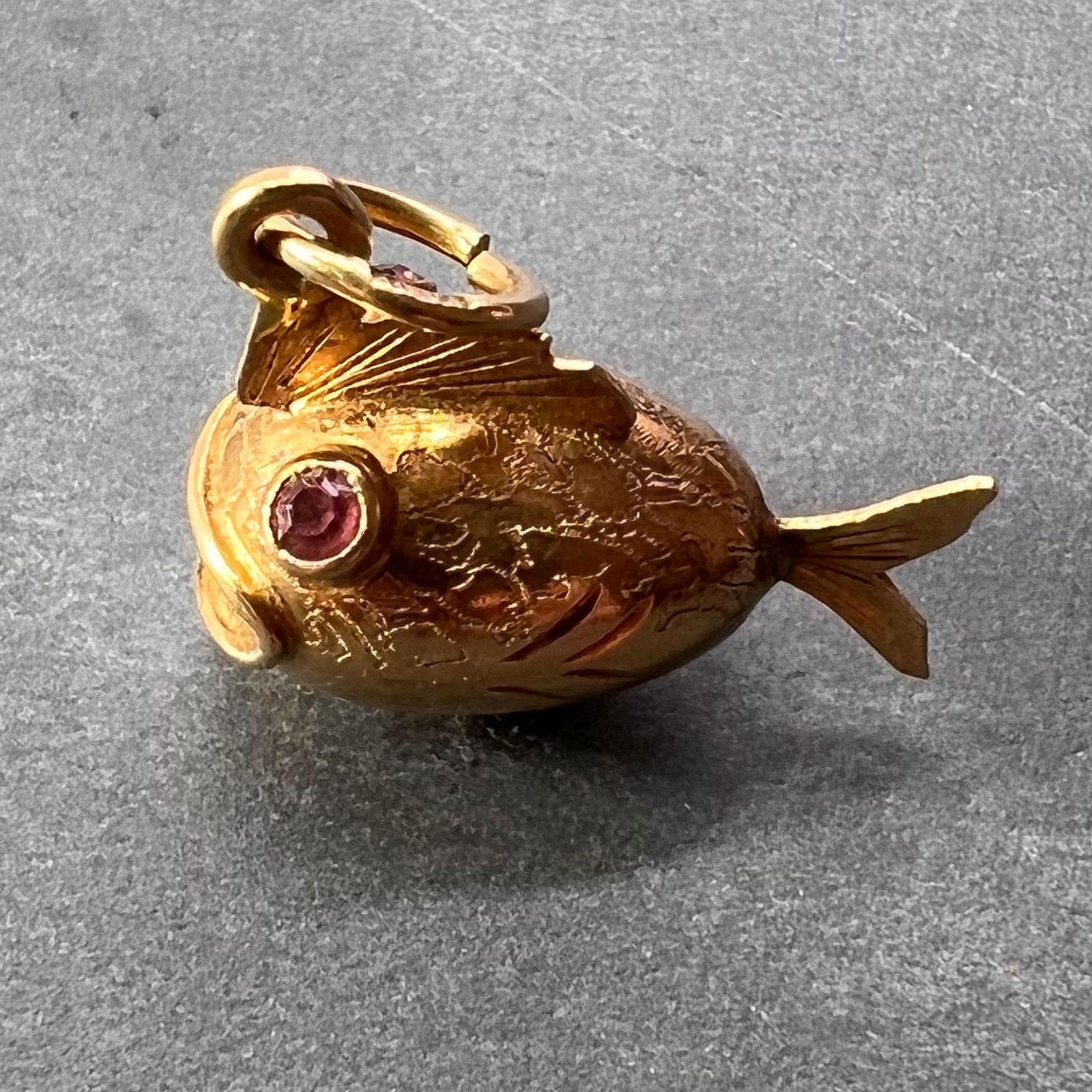 An 18 karat (18K) yellow gold charm pendant designed as a fish with pink paste eyes. Stamped 750 for 18 karat gold and 10VA for Italian manufacture to the jump ring.

Dimensions: 1.8 x 1.5 x 0.95 cm (not including jump ring)
Weight: 2.07 grams