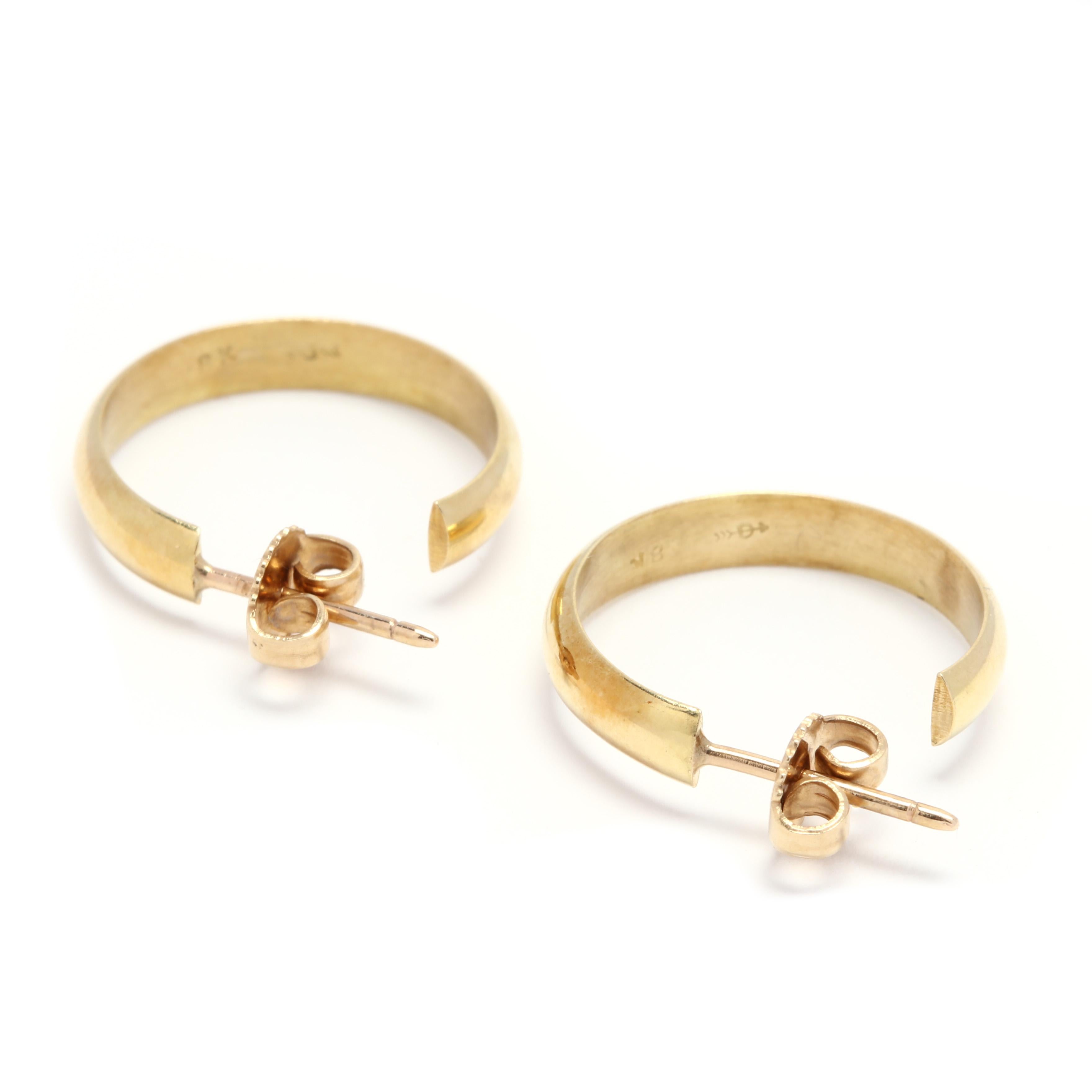 A pair of 18 karat yellow gold flat hoop earrings. These earrings feature a slightly curved polished hoop earring with push back closures.

Length: 3/4 in.

Width: 3.65 mm

3.49 dwts.

* Please note that this is a vintage item and may show signs of