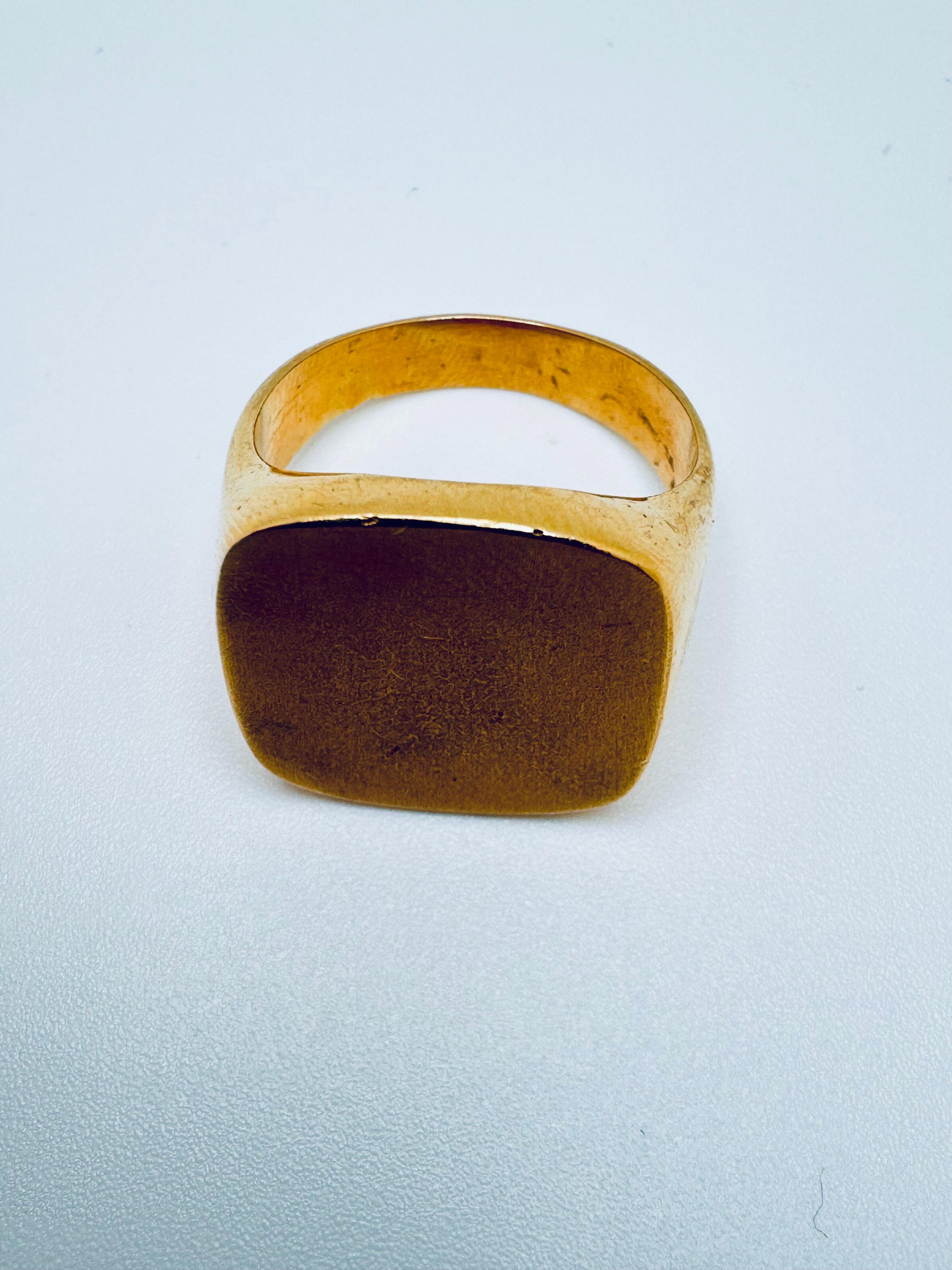 Crafted in luxurious 18K yellow gold, this bold signet ring features a substantial square face measuring approximately 18x18.5mm. The smooth, polished surface offers a timeless canvas—perfect for engraving or left unadorned for a sleek, minimalist