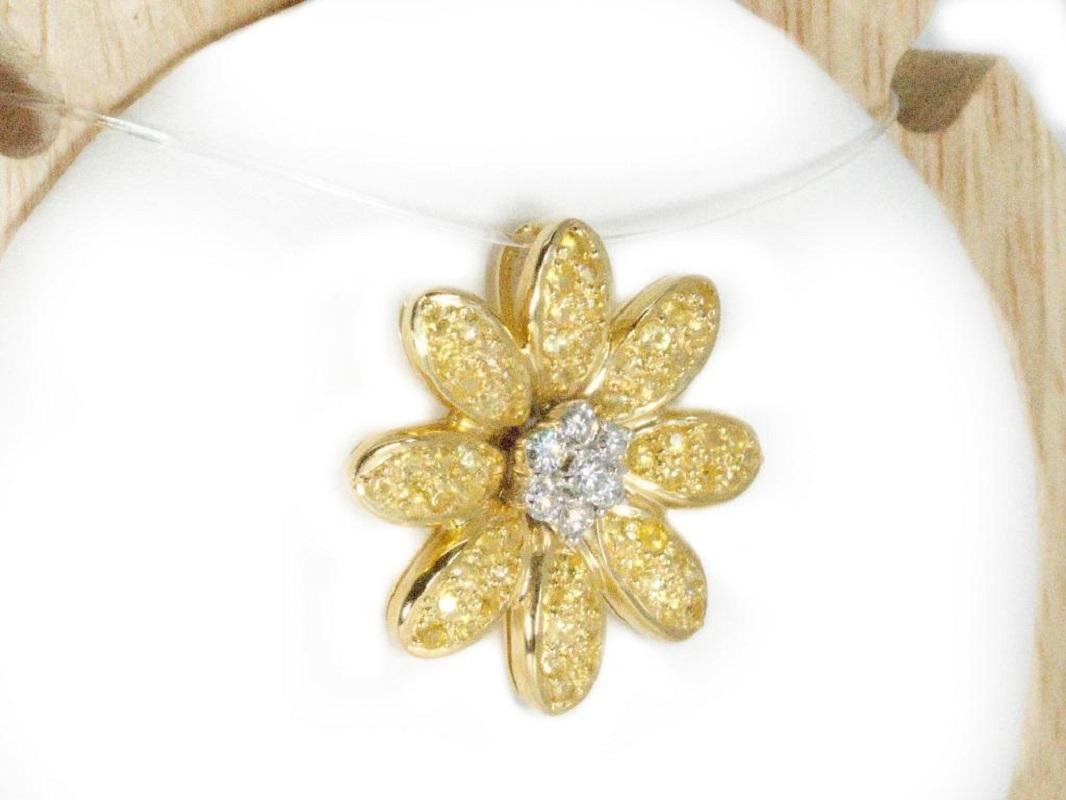 Beautiful Flower Design in an 18K Yellow Gold Pendant with Round Yellow Sapphire in 1.85 Total Carat and Round Diamonds in 0.31 Total Carat.

-64 sapphire main stones of 0.0245 ct. each, total: 1.57 ct.
cut: round
color: yellow

-7 diamond side